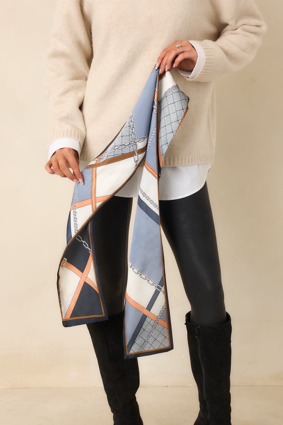 Color-block scarf combines navy, muted blue, ivory, and warm peach sections with a narrow contrasting border.