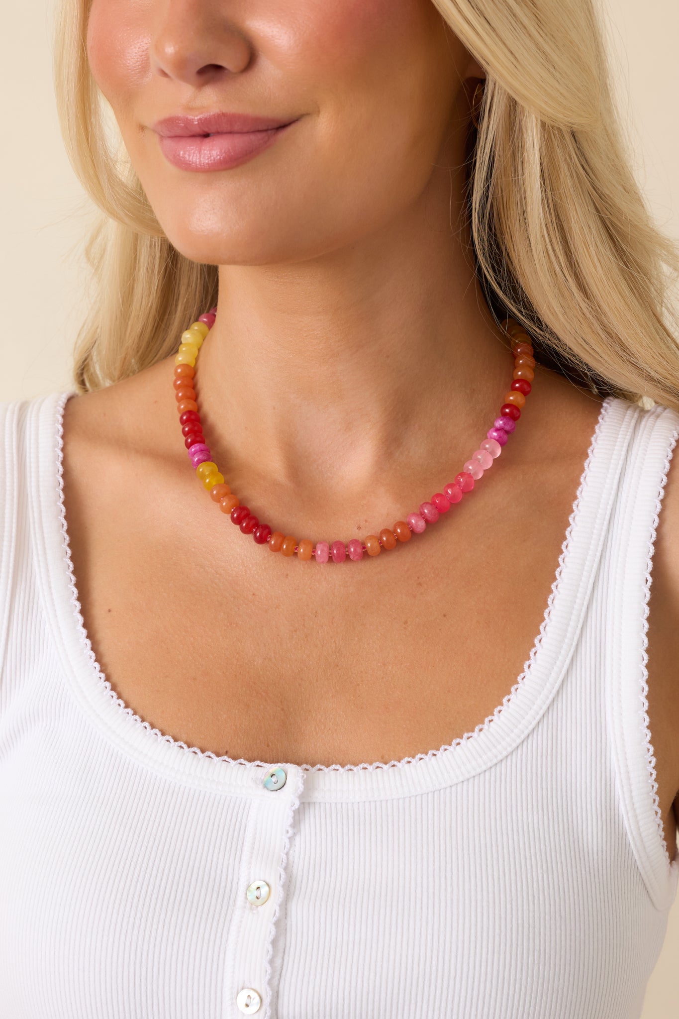 Colorful beaded necklace featuring a vibrant mix of pink, coral, orange, and yellow glass beads with a lightweight design.
