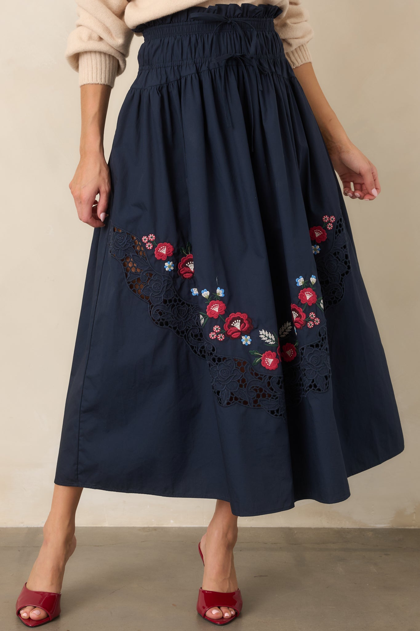 Lightweight 100% cotton skirt showcasing vibrant floral embroidery curving across the front, a textured lace panel, and a relaxed silhouette with a gathered waist.
