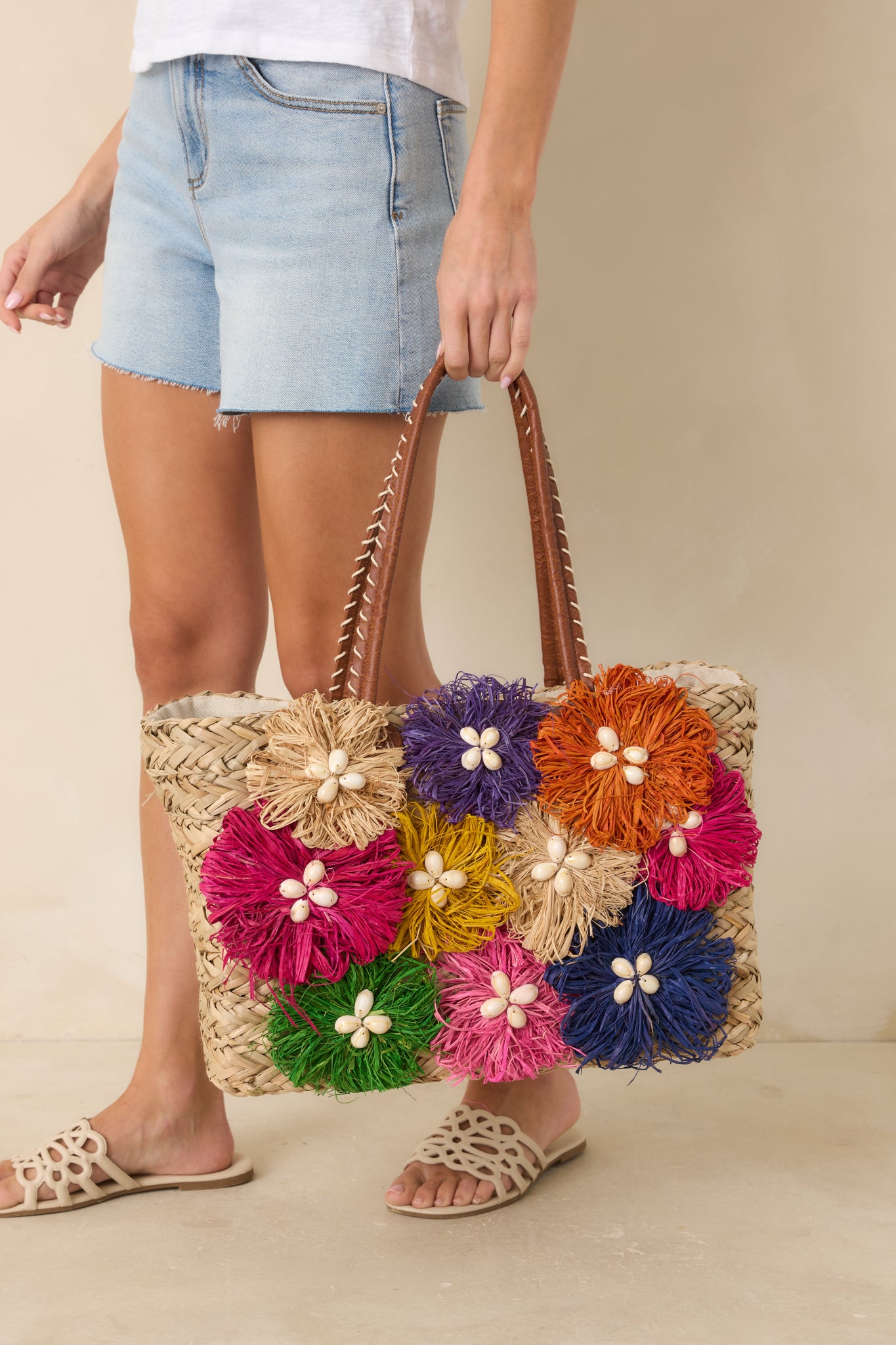 Colorful handbag featuring smooth wrapped handles, detailed stitching, and a refined structured shape.