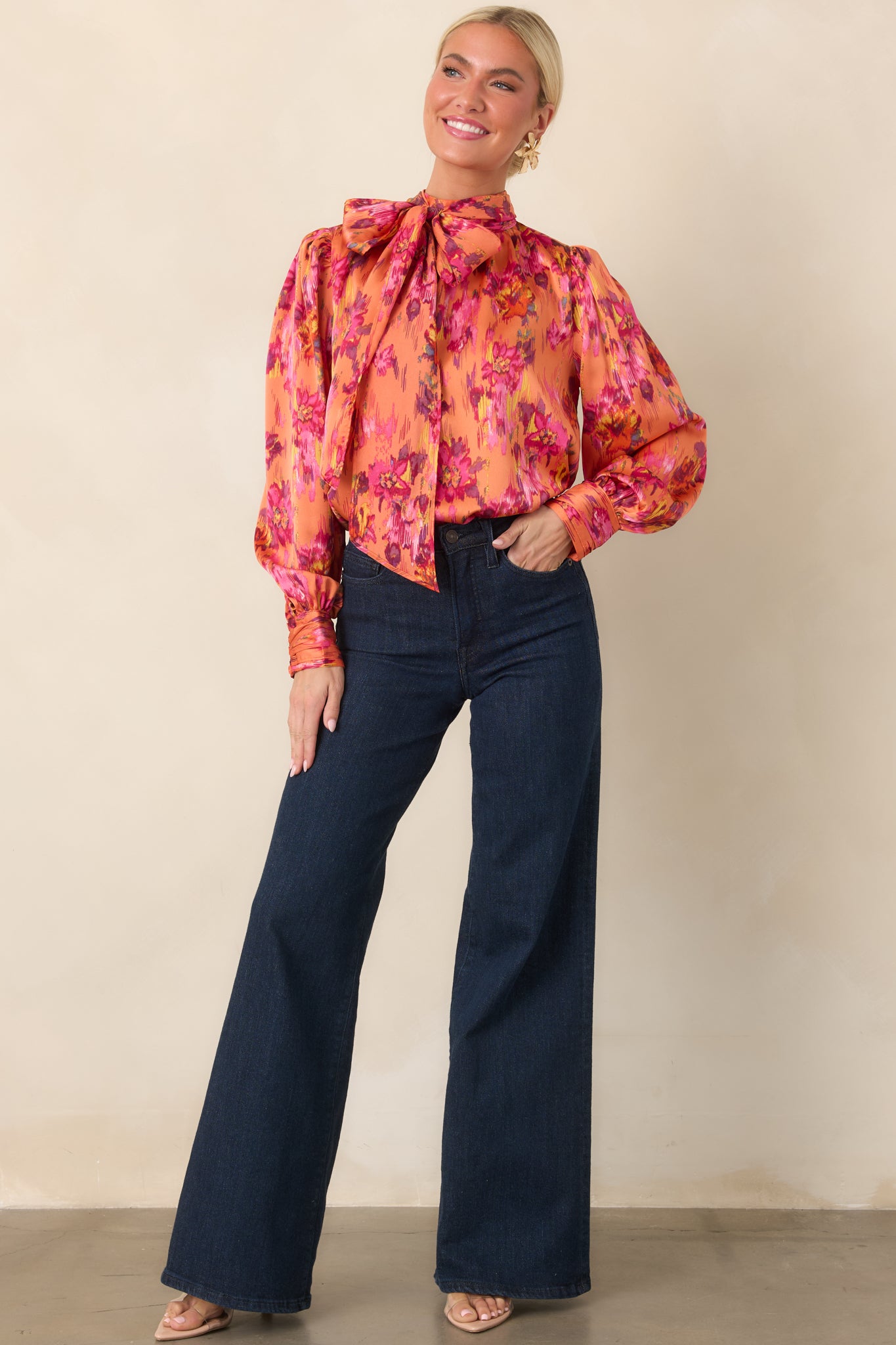 Colorful polyester satin blouse featuring a dramatic tie neckline, lightly gathered shoulders, long balloon sleeves, and buttoned cuffs with a soft sheen.