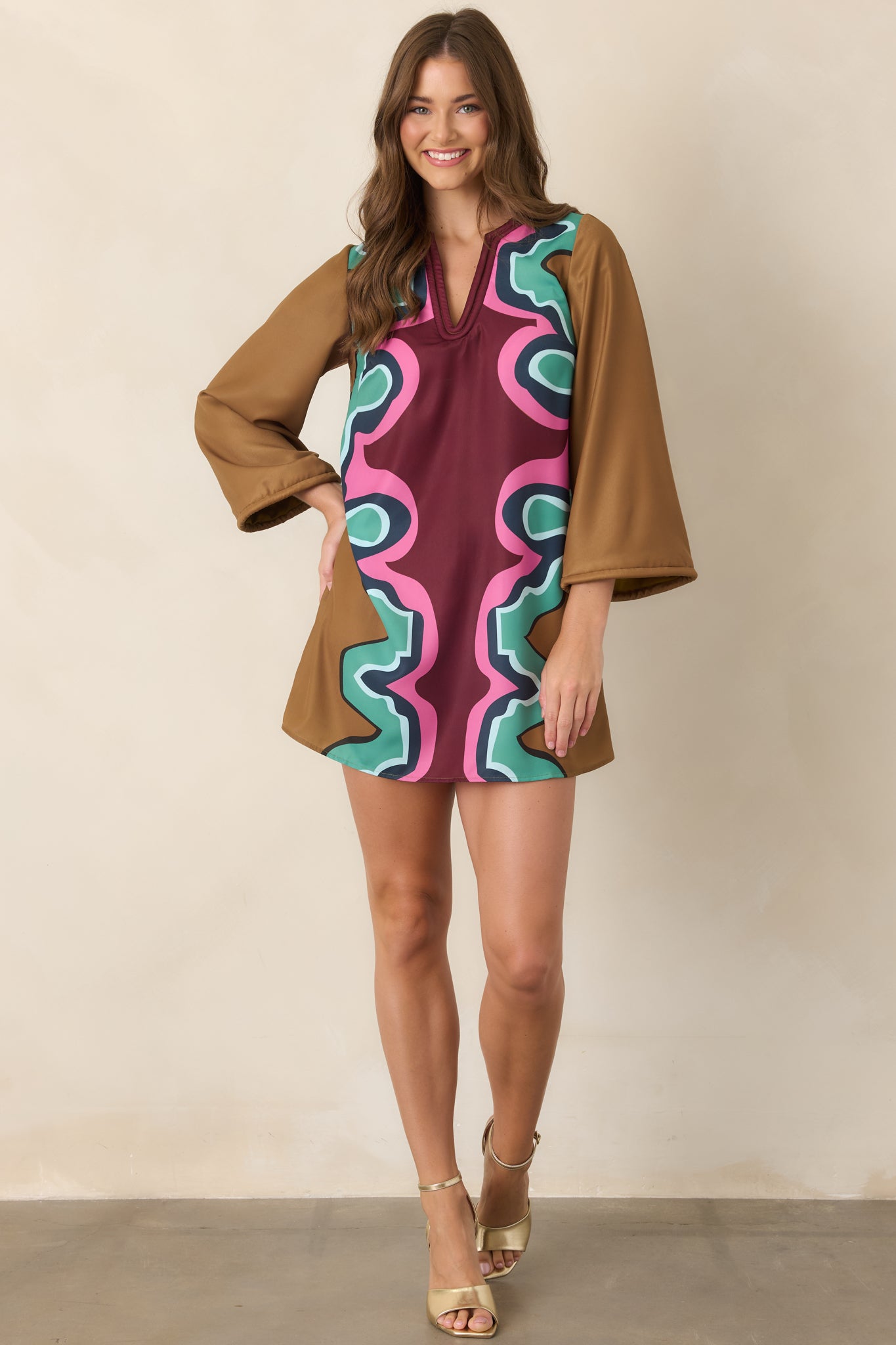 Colorful poly twill mini dress showcasing the bold Serpentine pattern in burgundy, camel, seafoam green, pink, navy, and light blue.