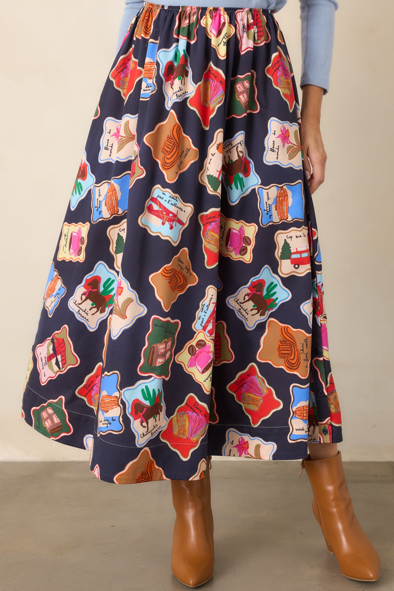 Flowing skirt detail showcasing the playful collection of colorful stamp-style illustrations and soft cotton and lyocell construction.