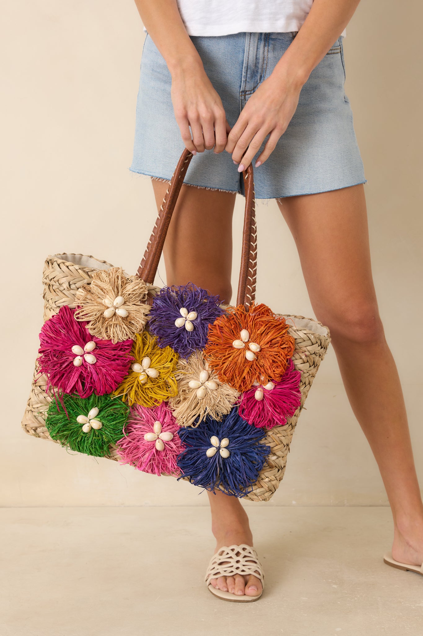Colorful structured tote bag featuring leather-wrapped handles, contrast whipstitch detailing, and spacious design.