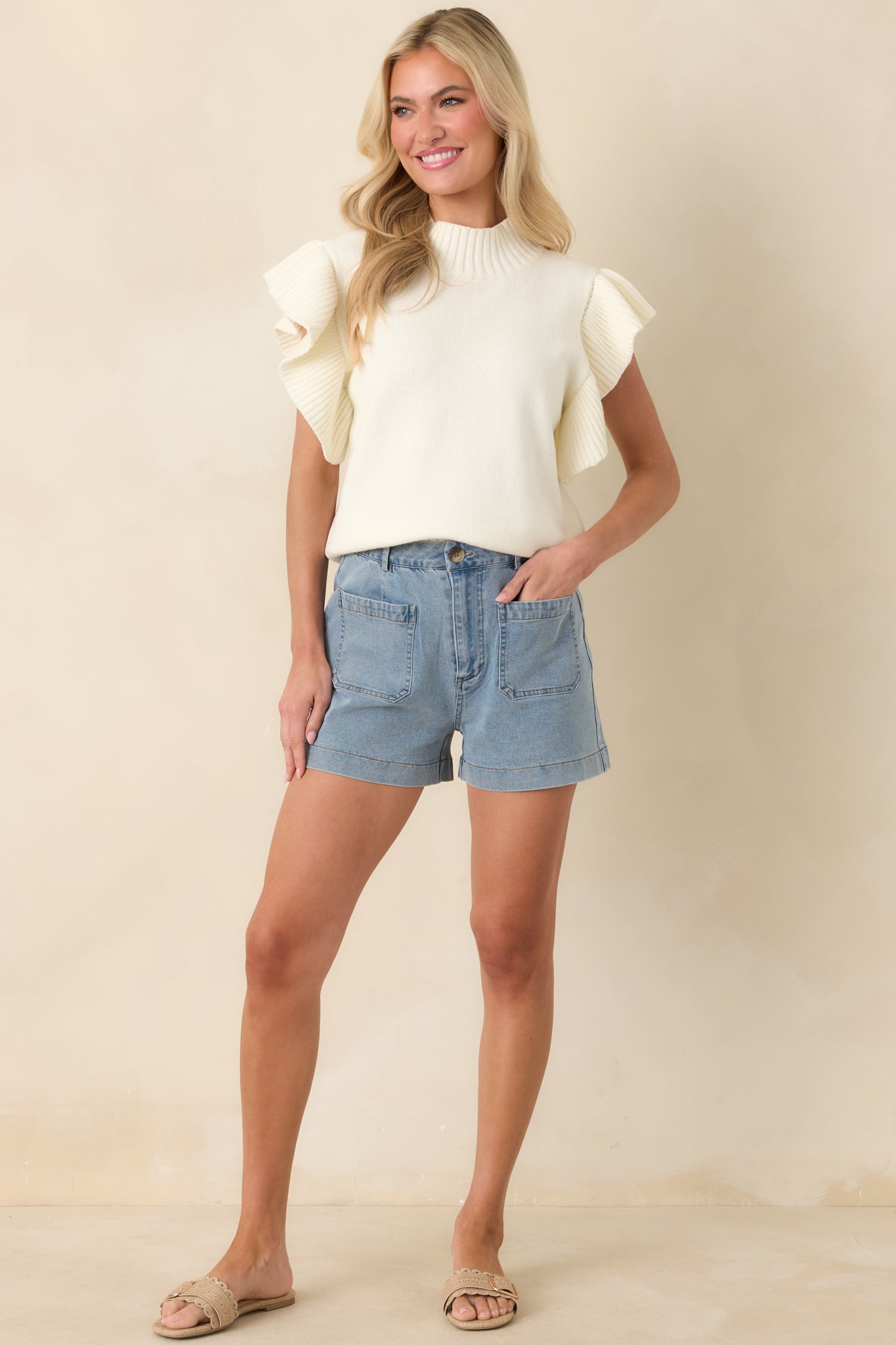 Comfortable ivory knit top with ribbed detailing at the neckline and hem, highlighted by textured flutter sleeves.
