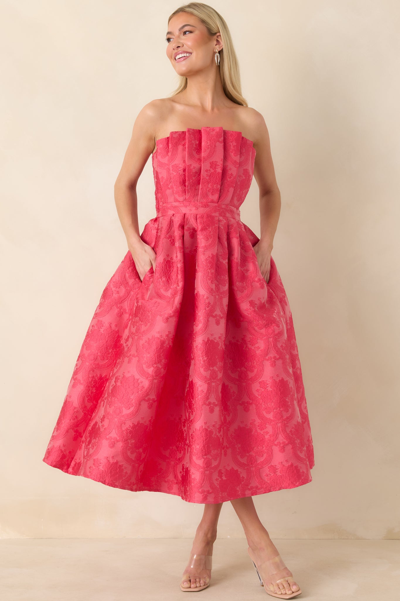 Complete shot of the pink jacquard midi dress highlighting its functional pockets and strapless design.