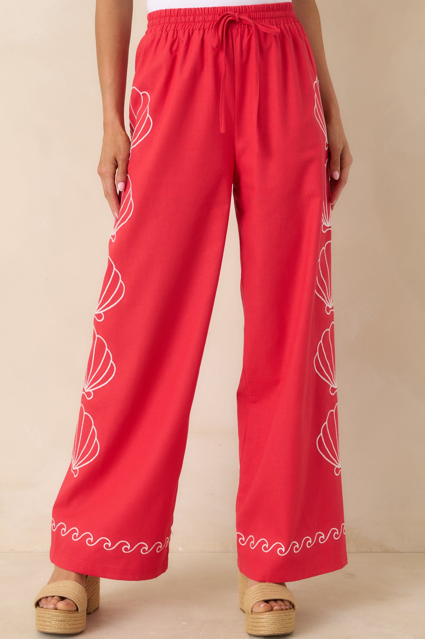 Contrast wave trim detail along hem of relaxed red pants.
