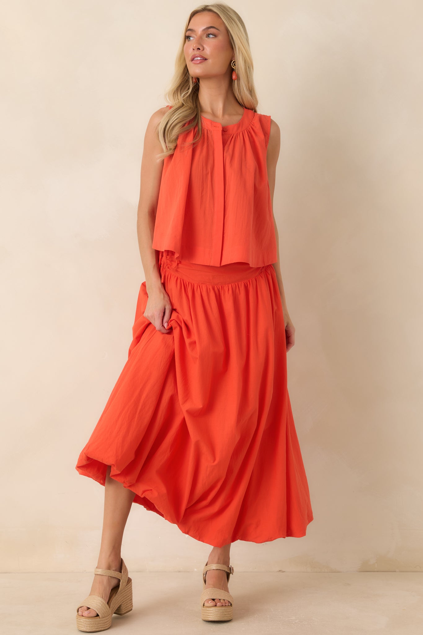 Lightweight 100% cotton coral orange maxi skirt featuring a wide gathered waistband, adjustable side ties, and a full flowing silhouette.