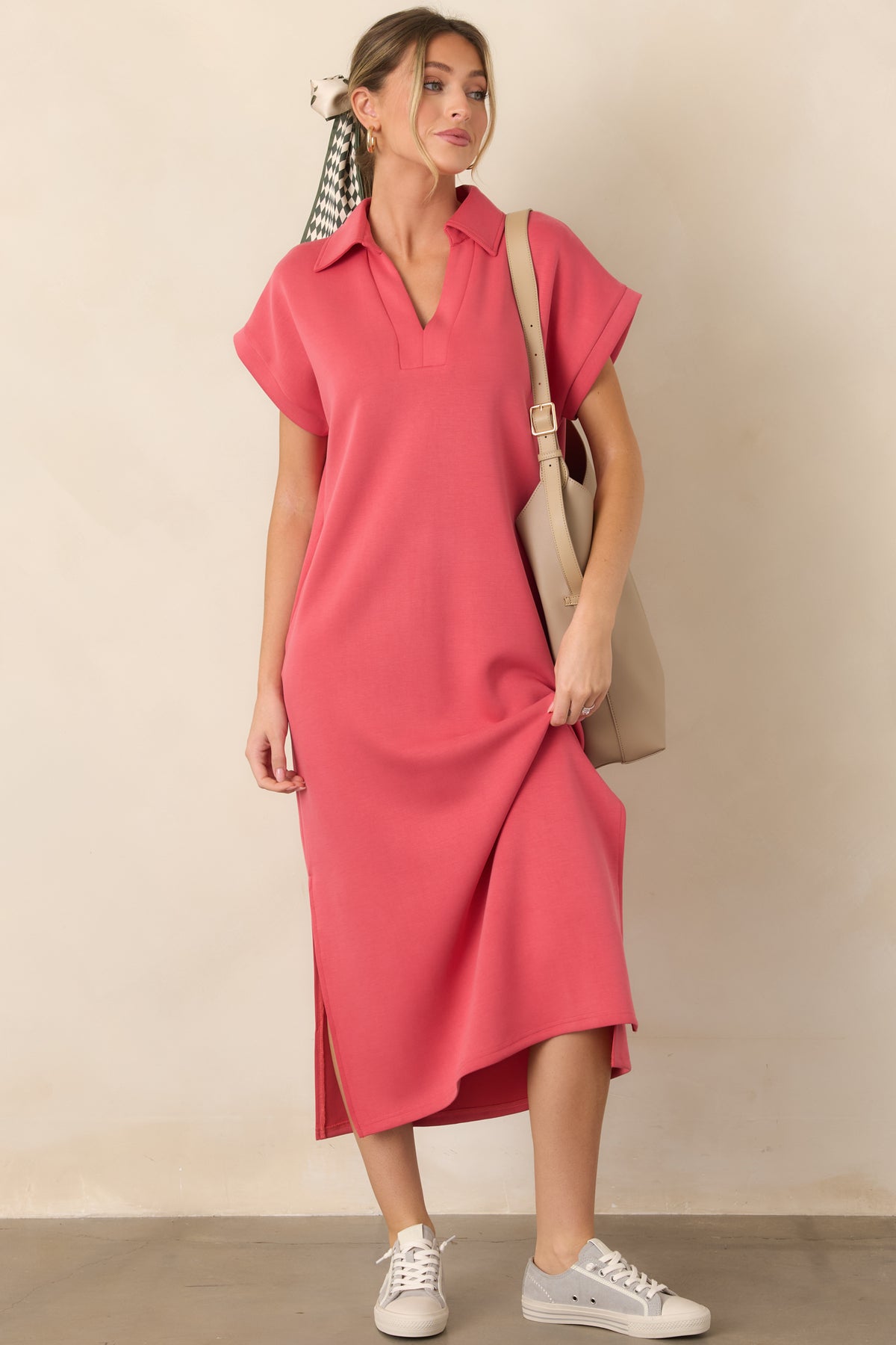 Coral pink midi dress showcasing a notch V-neck collar, buttery soft fabric, short sleeves, and flowing side vent slits.