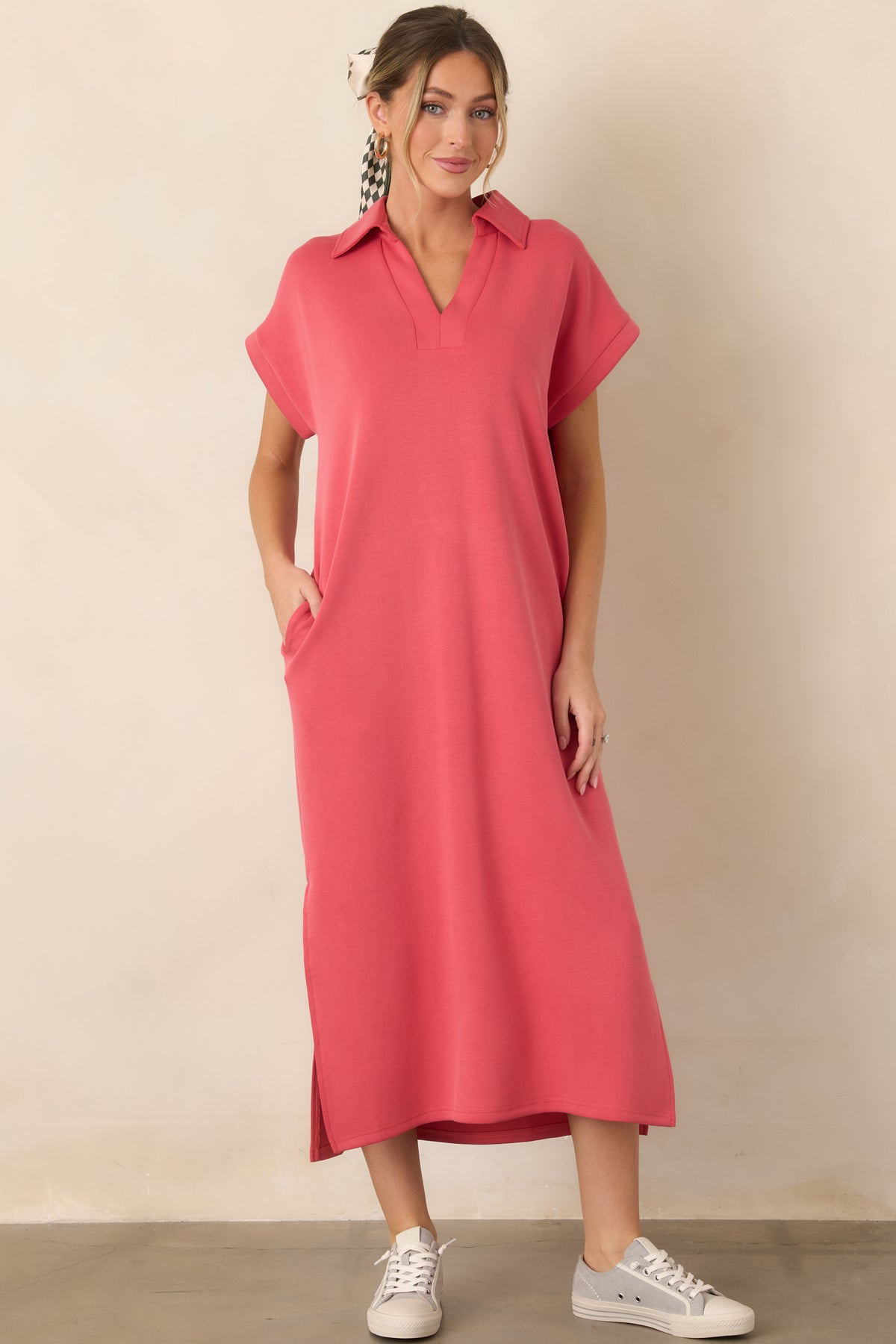 Coral pink midi dress with a relaxed silhouette, short sleeves, collared notch V-neckline, functional side pockets, and vented hem.