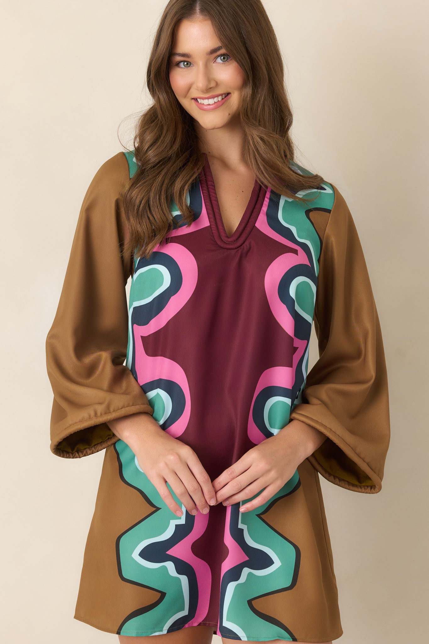 Close view of the mini dress highlighting the soft corded V-neckline and colorful Serpentine print across the structured poly twill fabric.
