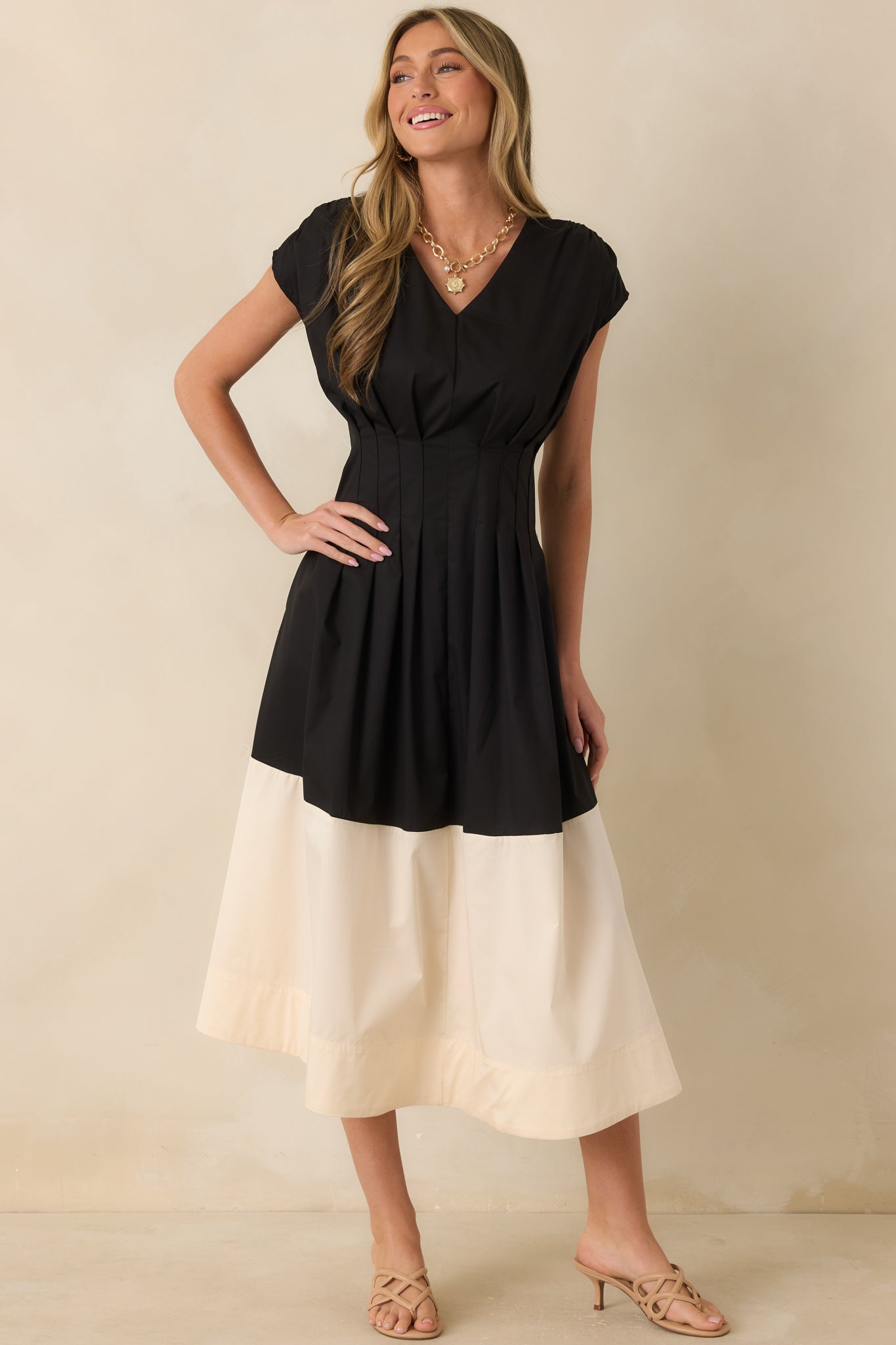 Cotton blend black and ivory midi dress featuring a softly pleated bodice, cap-style sleeves, and an elegant flowing silhouette.
