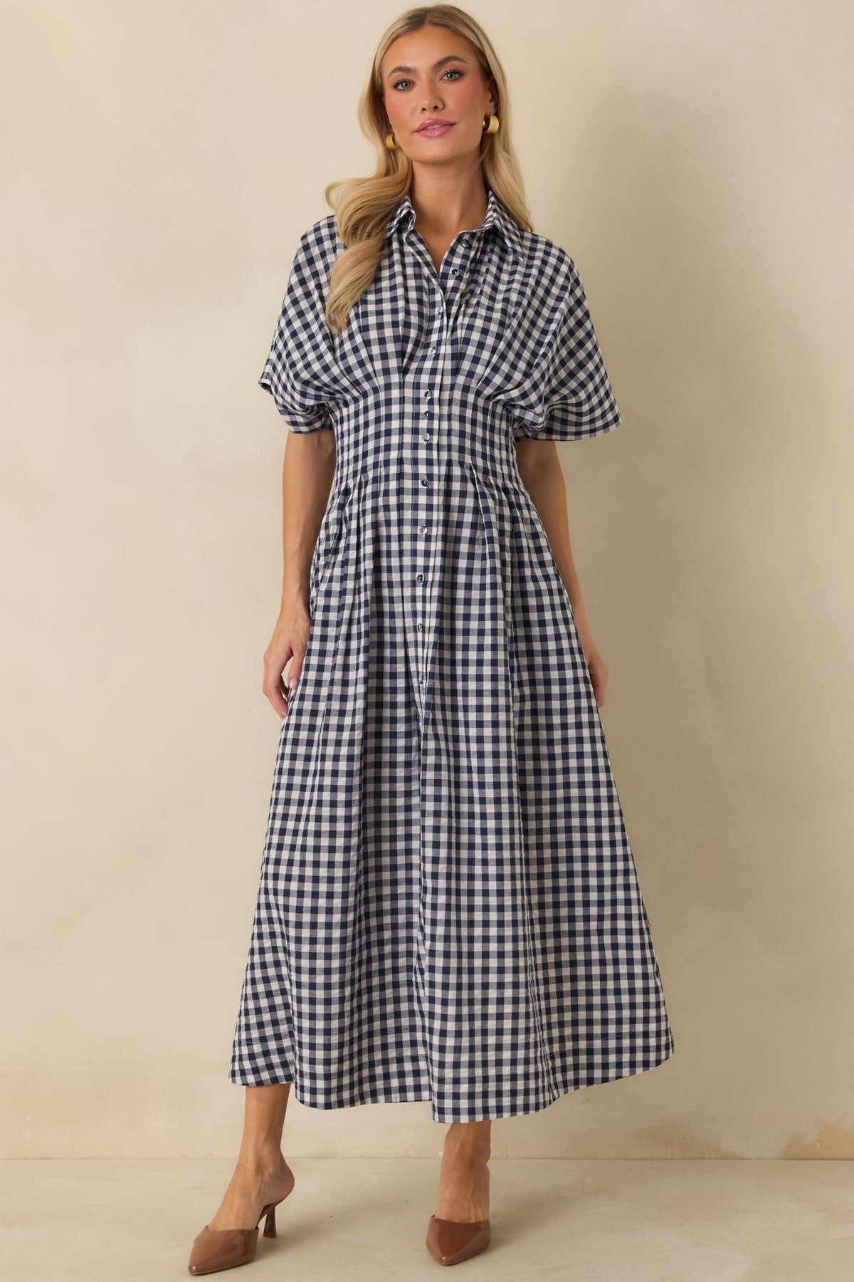 Cotton-blend gingham dress showcasing a pointed collar, button-front closure, and softly flowing midi skirt.
