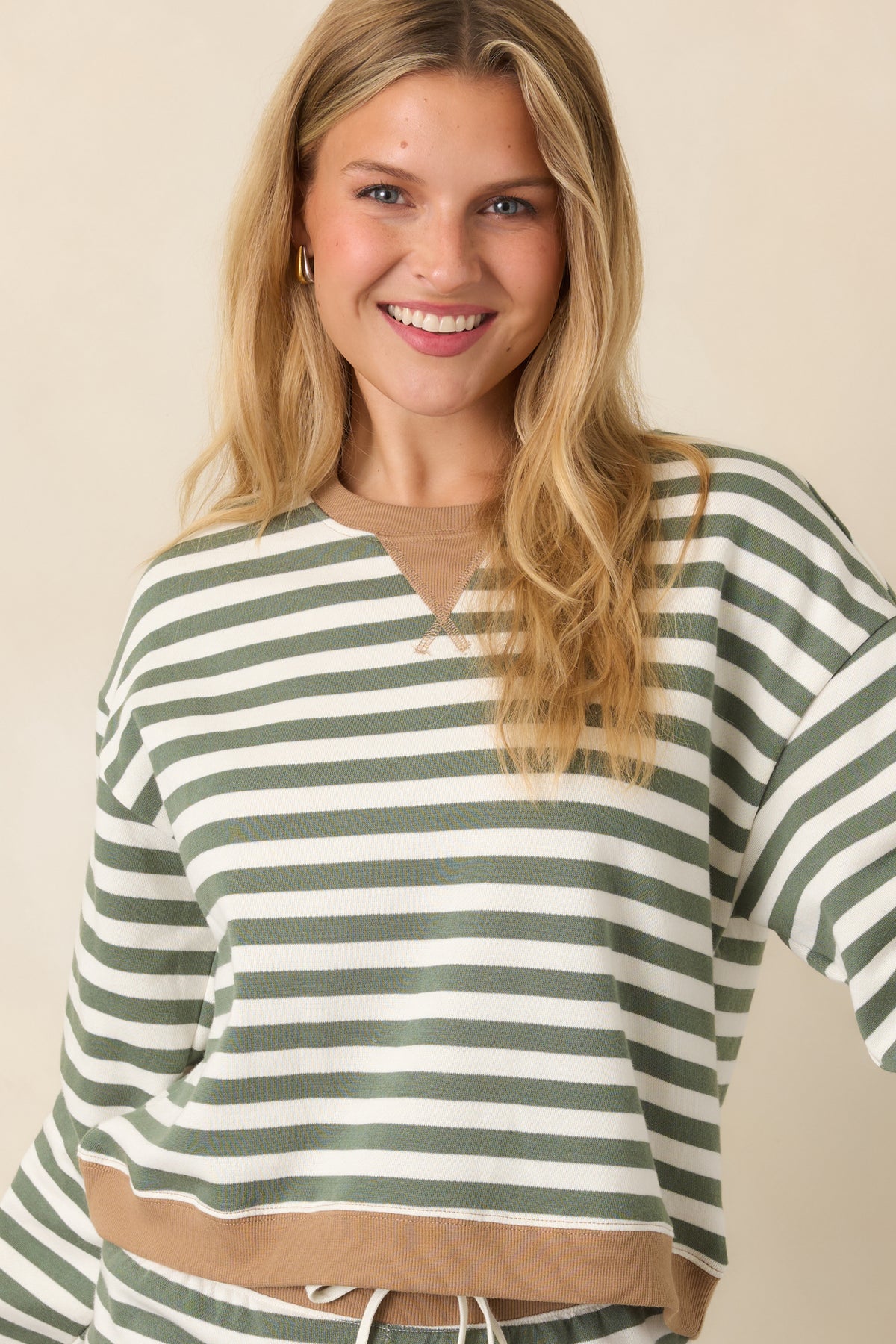 Cotton-blend striped sweatshirt displaying muted green and ivory stripes with contrasting camel ribbed trim and dropped shoulders.