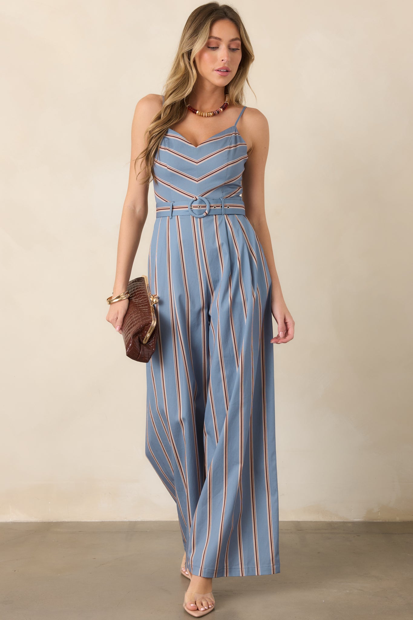 Cotton-blend jumpsuit showcasing contrasting chevron stripes across the bodice, elongated vertical stripes through the legs, and a defined belted waist.