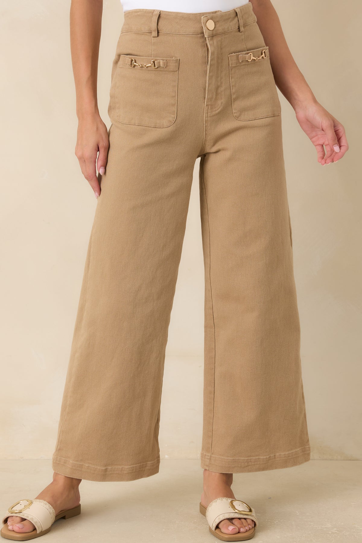 Detailed view of the cotton-blend fabric showcasing the front zip-and-button closure and belt loop accents.