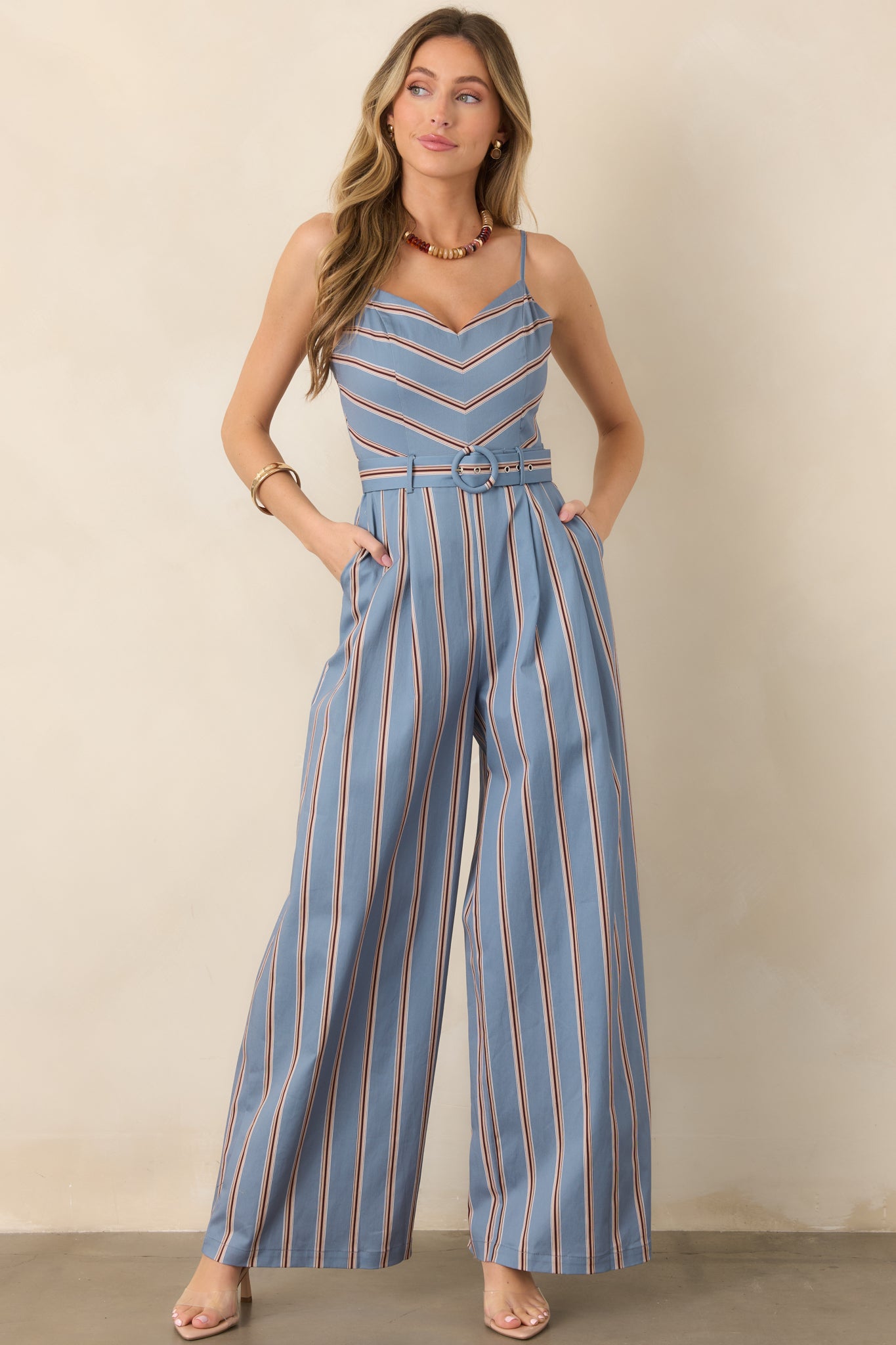 Cotton-blend striped jumpsuit featuring a defined sweetheart bodice, slender adjustable straps, matching belted waist, and full-length vertically striped legs.