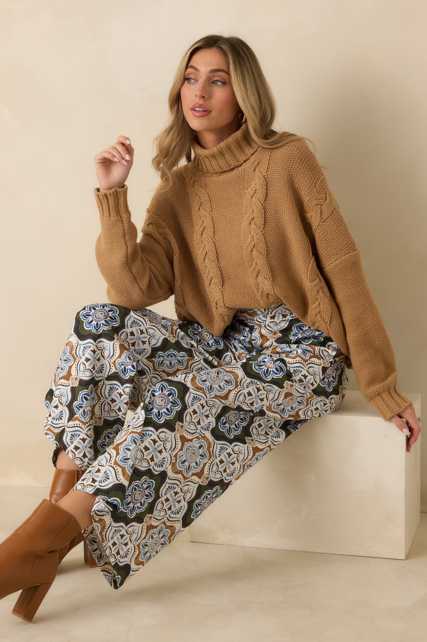 Soft cotton-blend sweater featuring chunky cable detailing, a wide ribbed turtleneck, dropped shoulders, and a relaxed oversized silhouette.