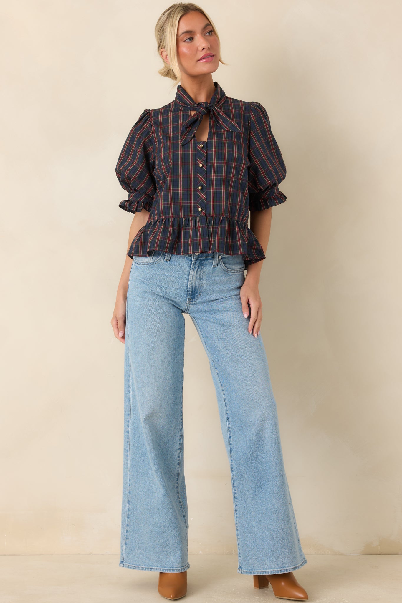 100% cotton blouse showcasing a tied neckline, feminine ruffled cuffs, and a shaped silhouette.