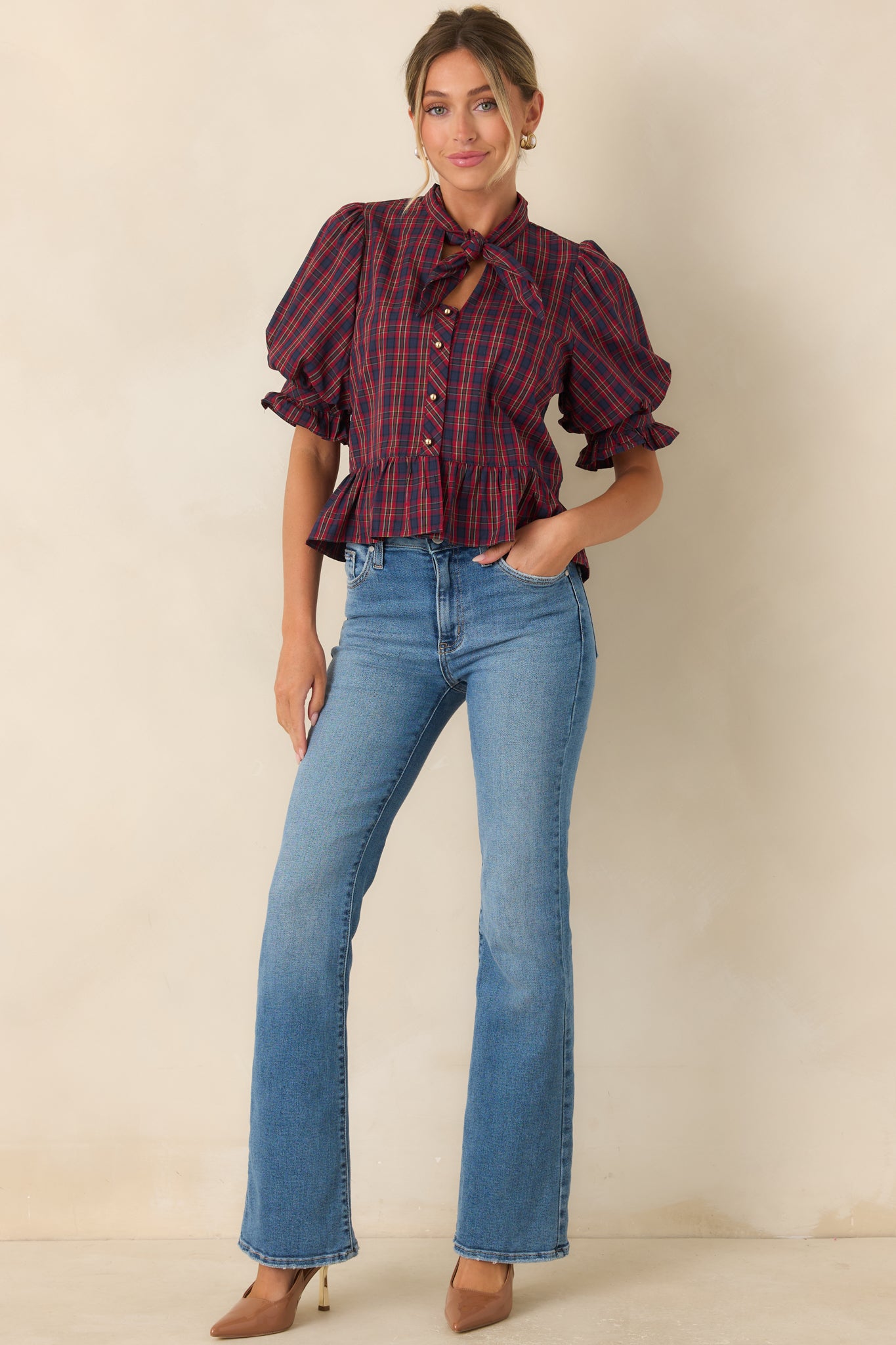 100% cotton blouse showcasing a tied neckline, ruffled sleeve cuffs, and a feminine gathered silhouette.
