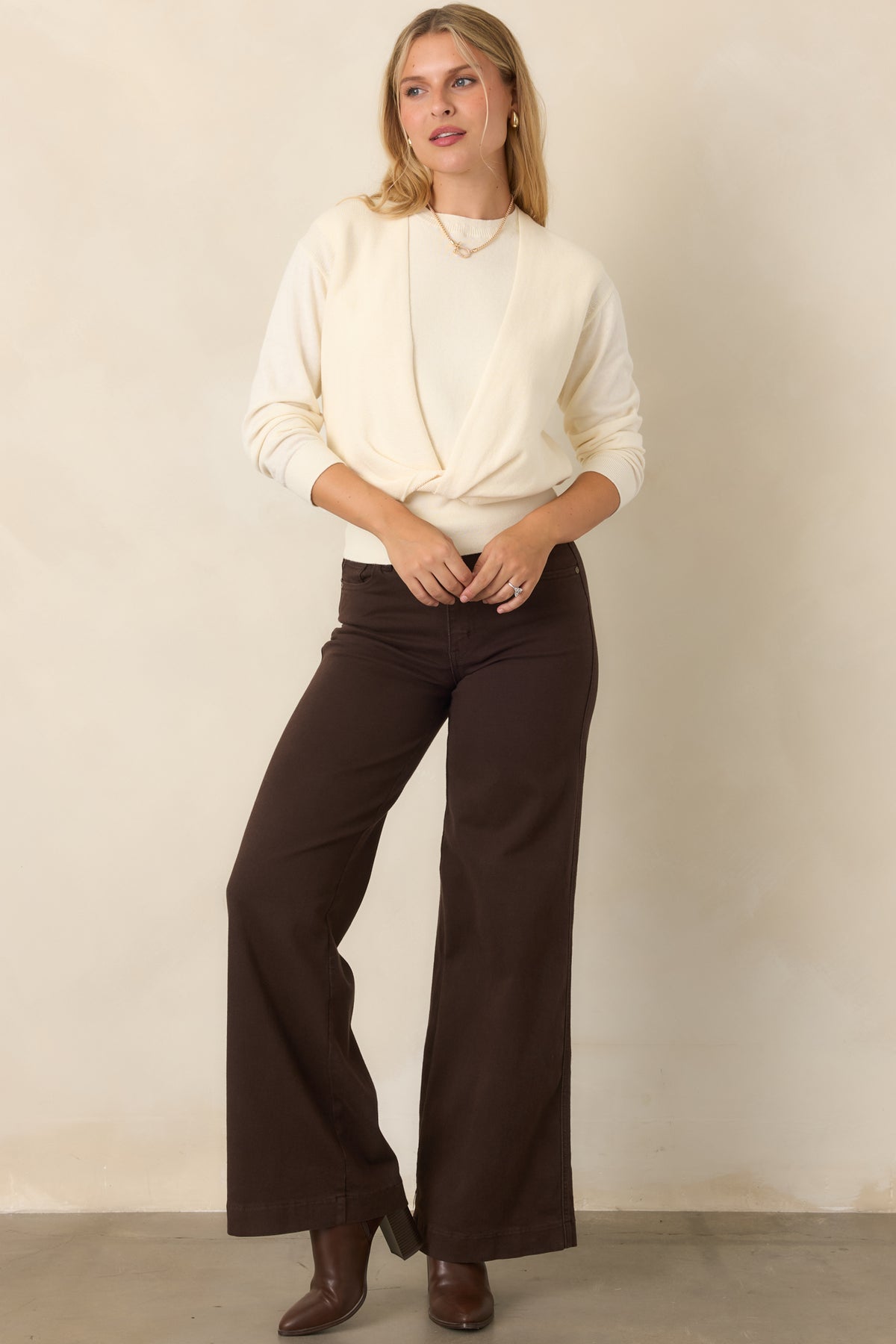 Cotton-cashmere blend sweater featuring a sleeveless crewneck base with a coordinating long-sleeve overlay that twists across the front and a wide ribbed hem.
