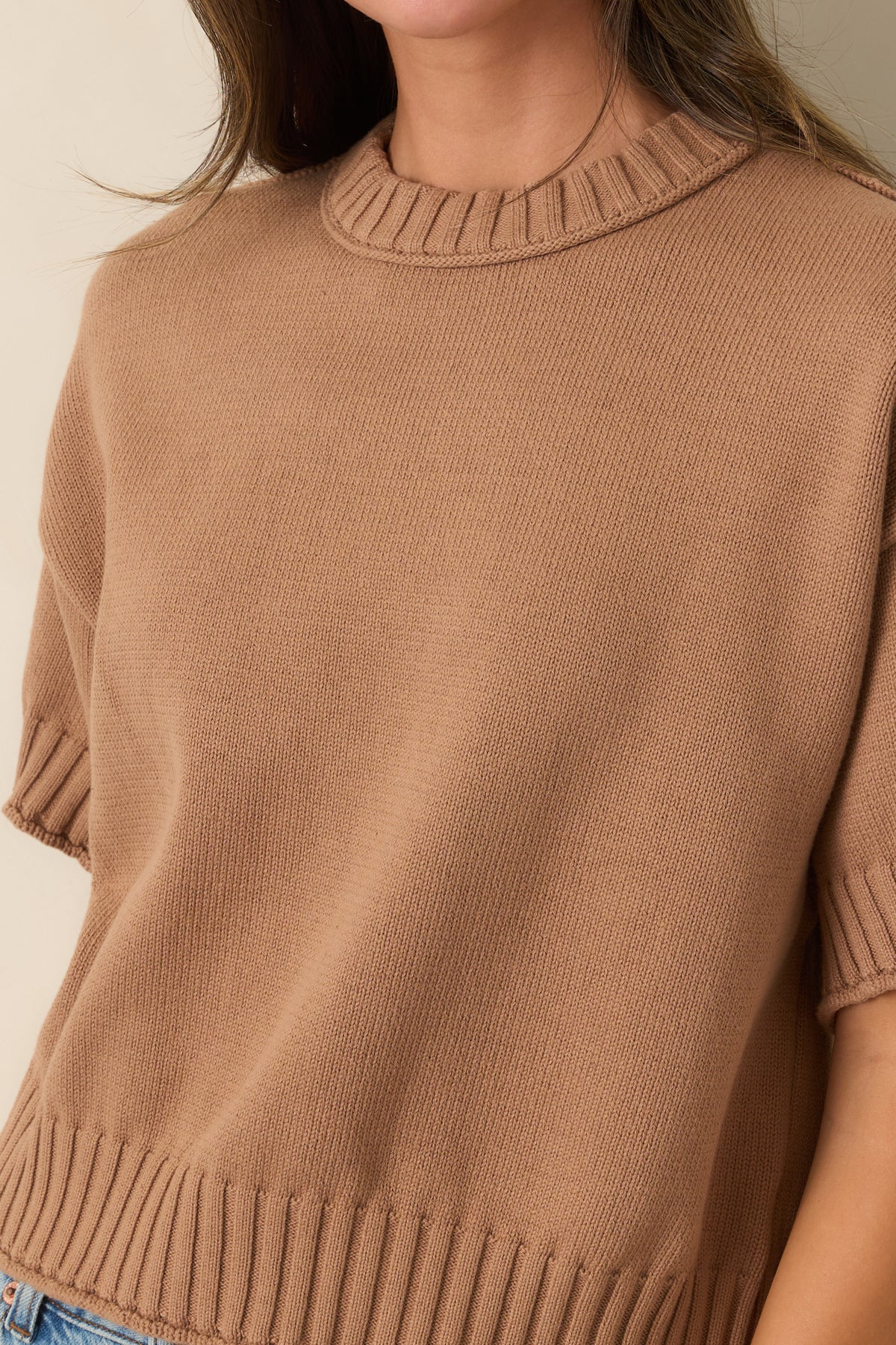 Close-up of the chunky ribbed crew neckline and textured cotton fabric.