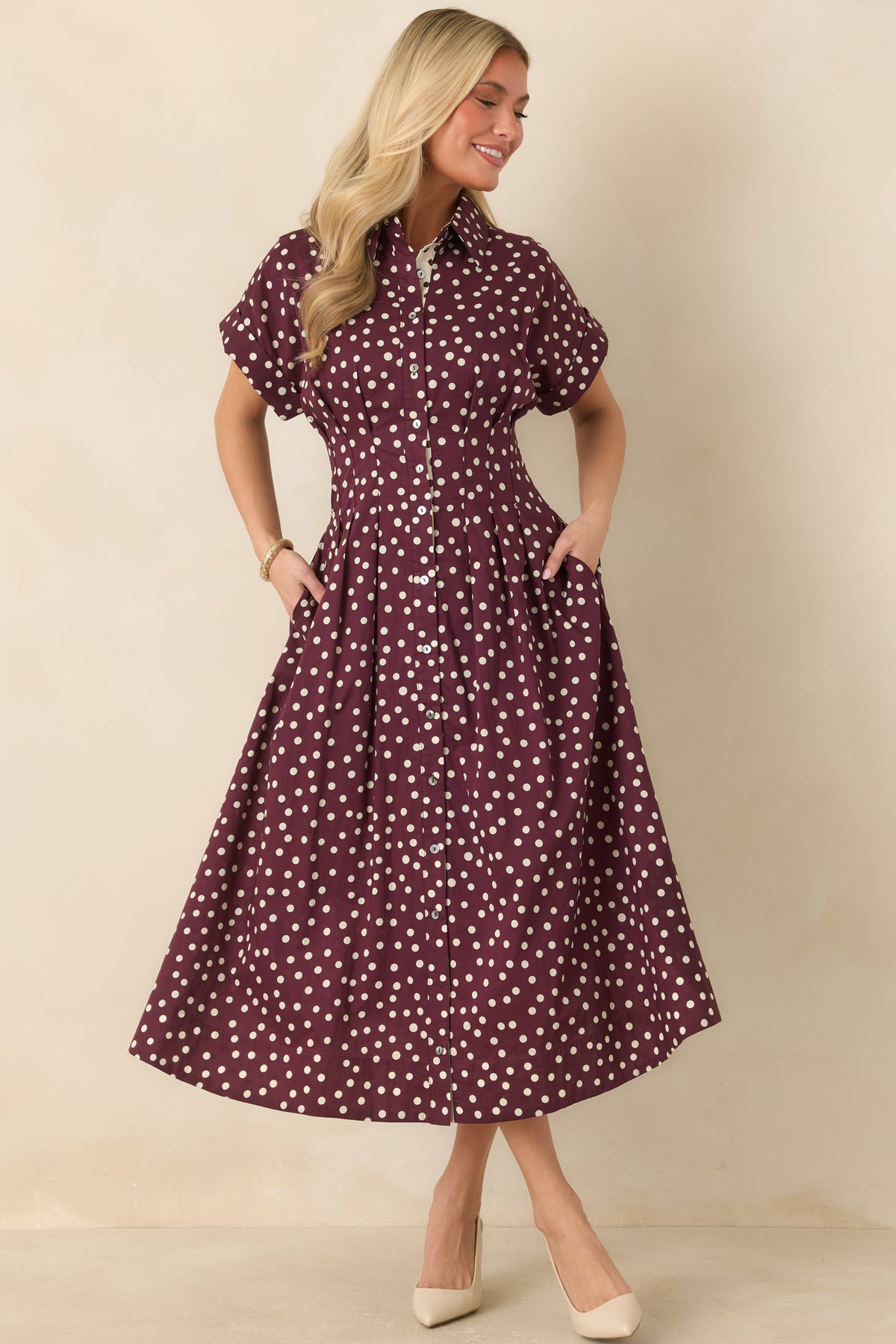 Cotton midi dress featuring a collared neckline, full button front, short sleeves, tailored waist seams, and gently flared skirt with side pockets.