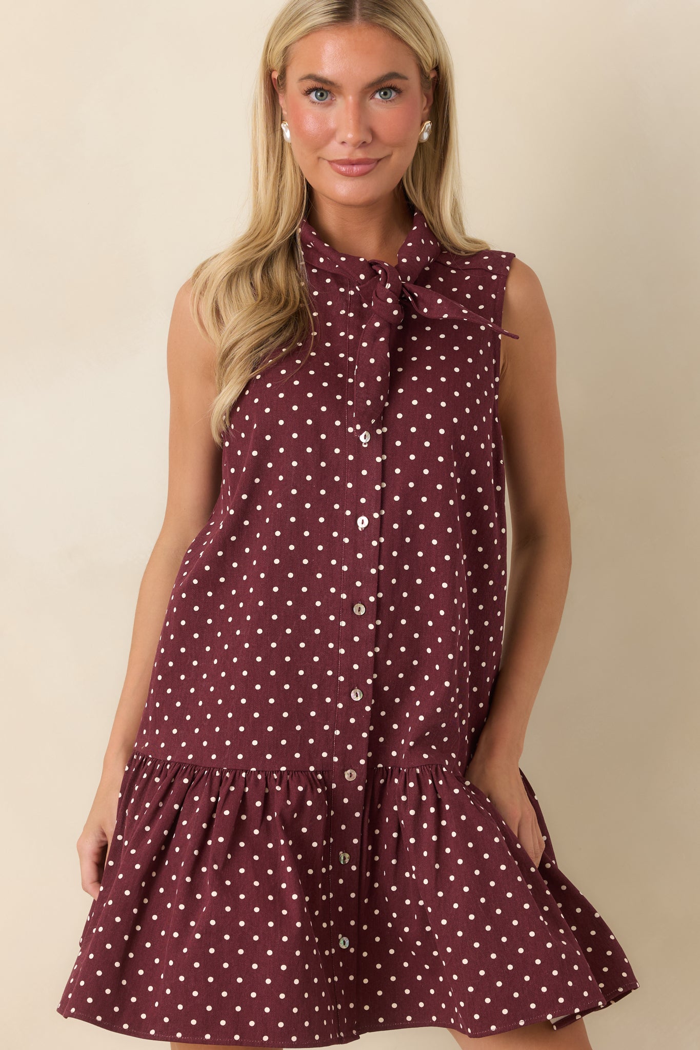 Close view of the cotton dress featuring the self-tie neckline, button-front styling, and neatly finished seam details.