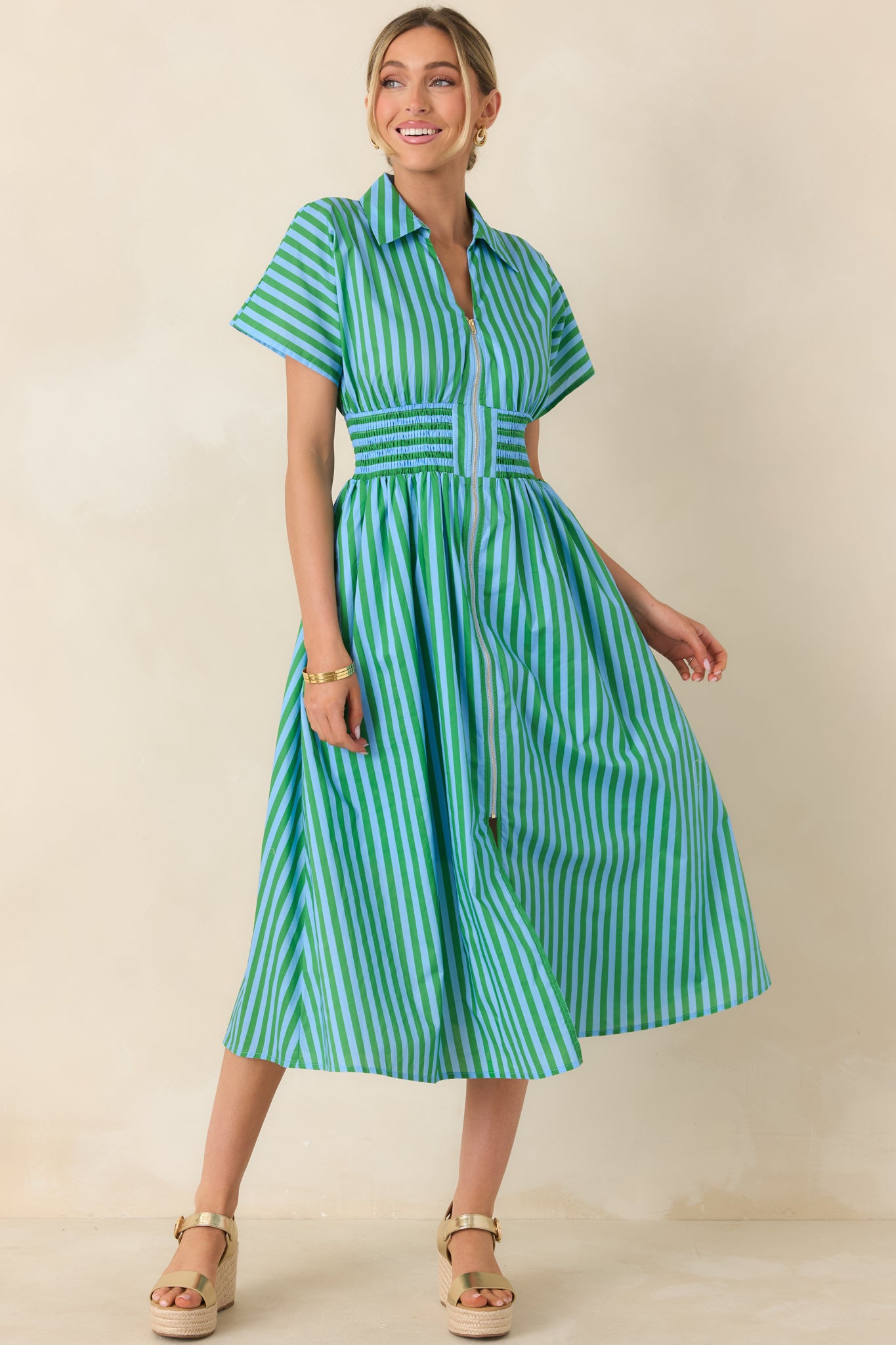 Front view of a lightweight cotton dress with playful vertical stripes, full A-line skirt, and tailored smocked waist.