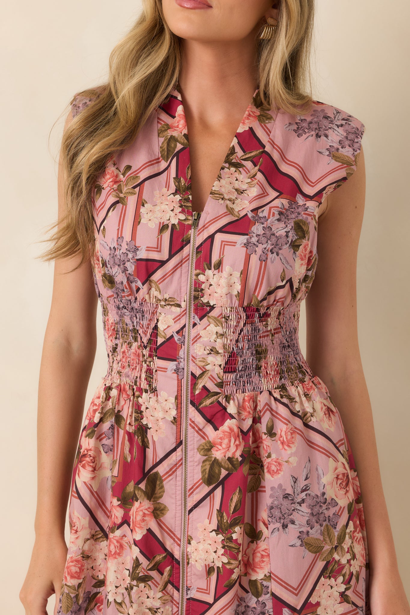 Close-up of the cotton midi dress highlighting the V-neckline, full front zipper, and textured smocked waist detail.
