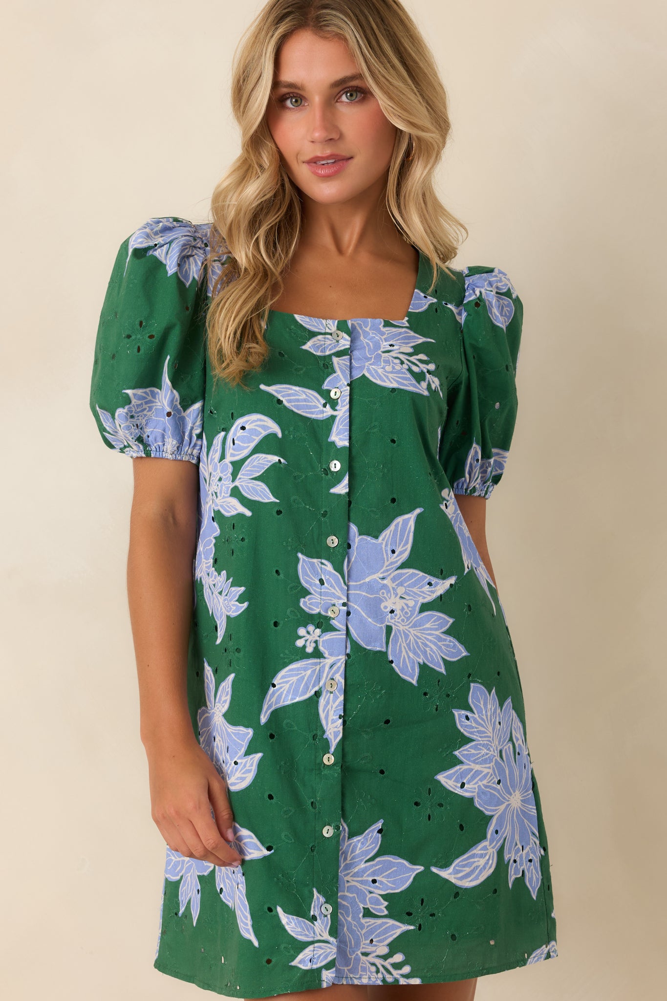 Cotton eyelet dress highlighting the feminine puff sleeves, square neckline, button front, and floral print.