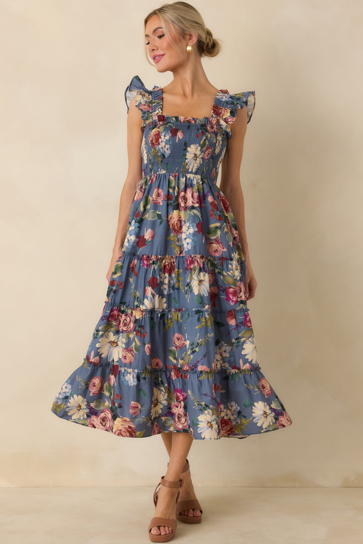Cotton midi dress in a blue floral print with a square neckline, smocked bodice, ruffled straps, and flowing tiered silhouette.