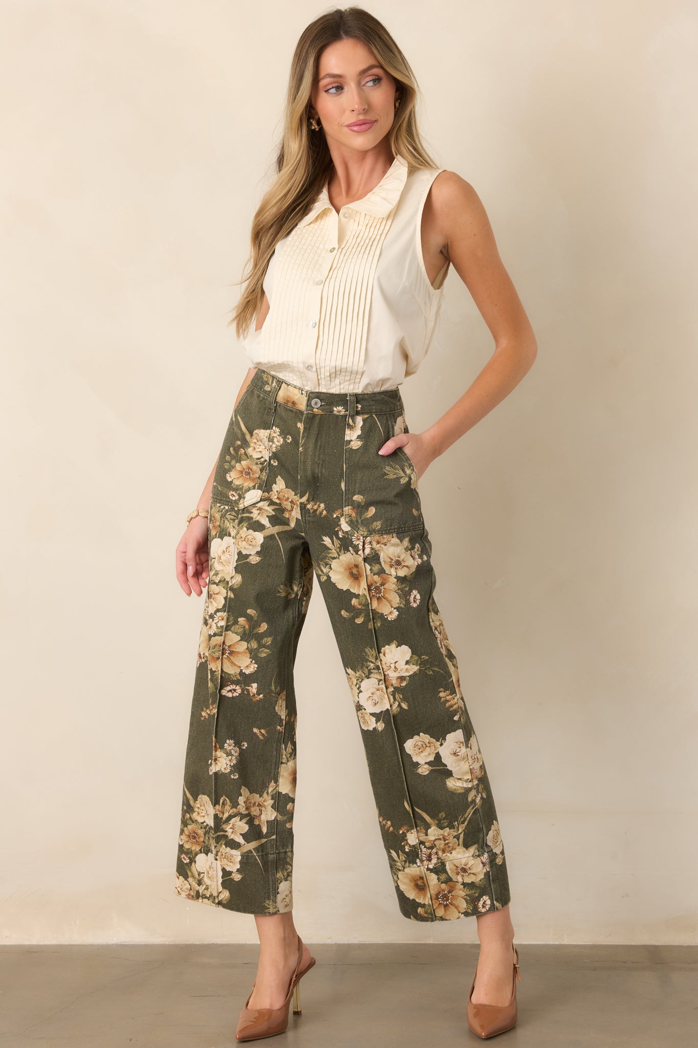 Structured olive cotton pants showcasing an ivory floral pattern, roomy wide legs, and practical patch pockets at the front and back.