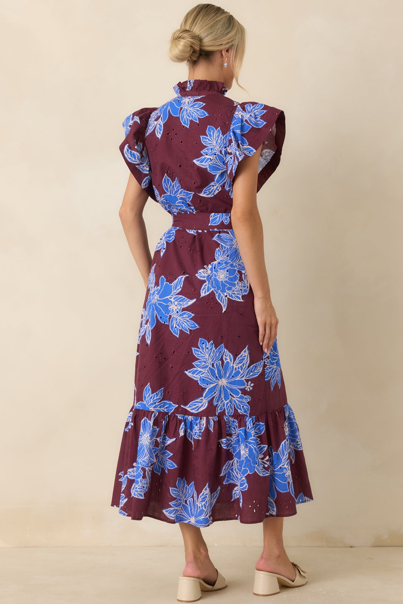 Rear view of the cotton dress featuring flutter sleeves, a relaxed silhouette, and a flowing ruffle hem.