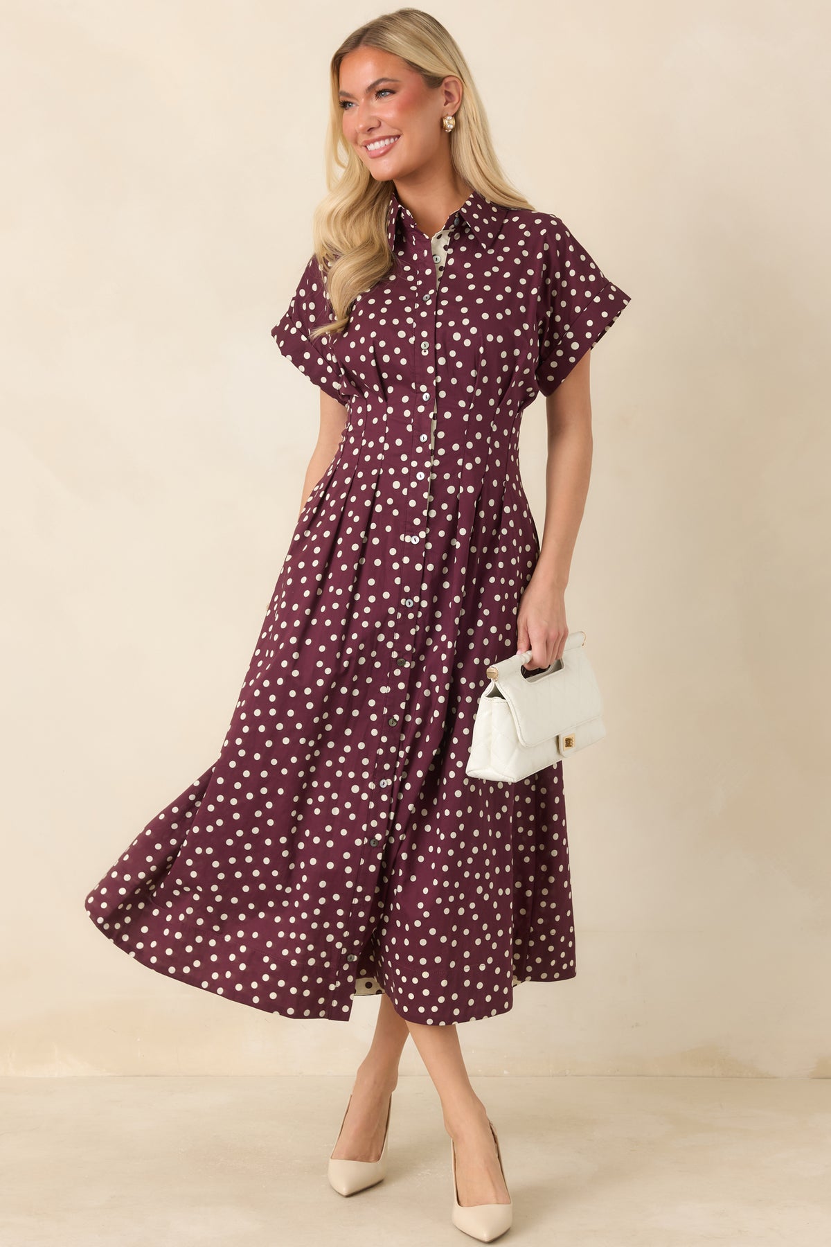 Cotton fit-and-flare midi dress featuring a collared neckline, ivory and plum polka dot pattern, short sleeves, and side pockets.