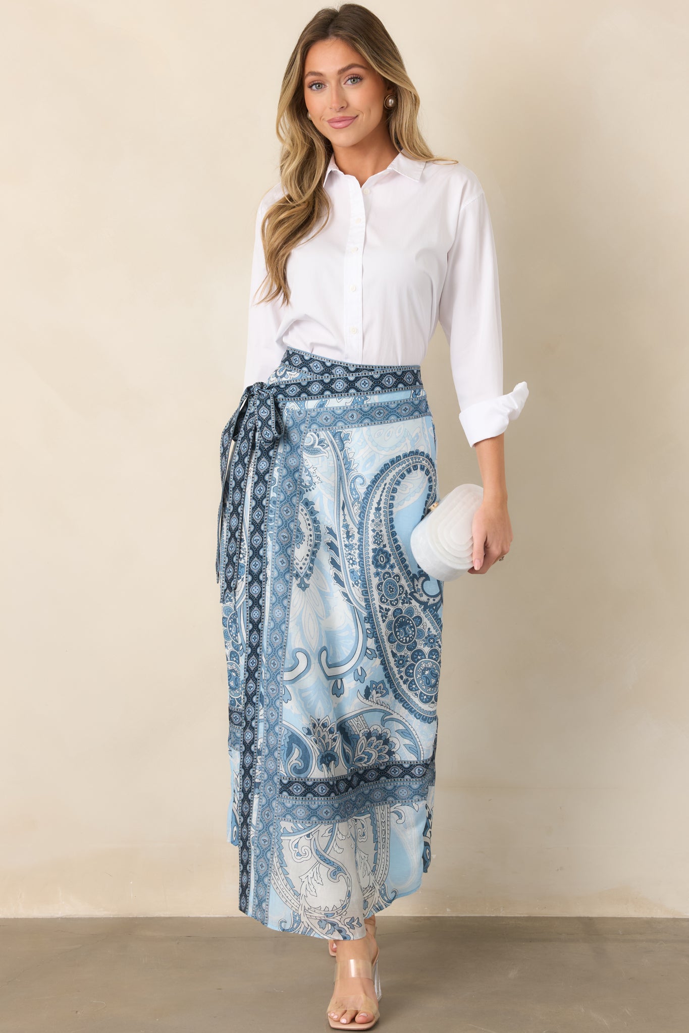 Cotton-lined maxi skirt designed with a wrap front, adjustable tie closure, and decorative border-print detailing.