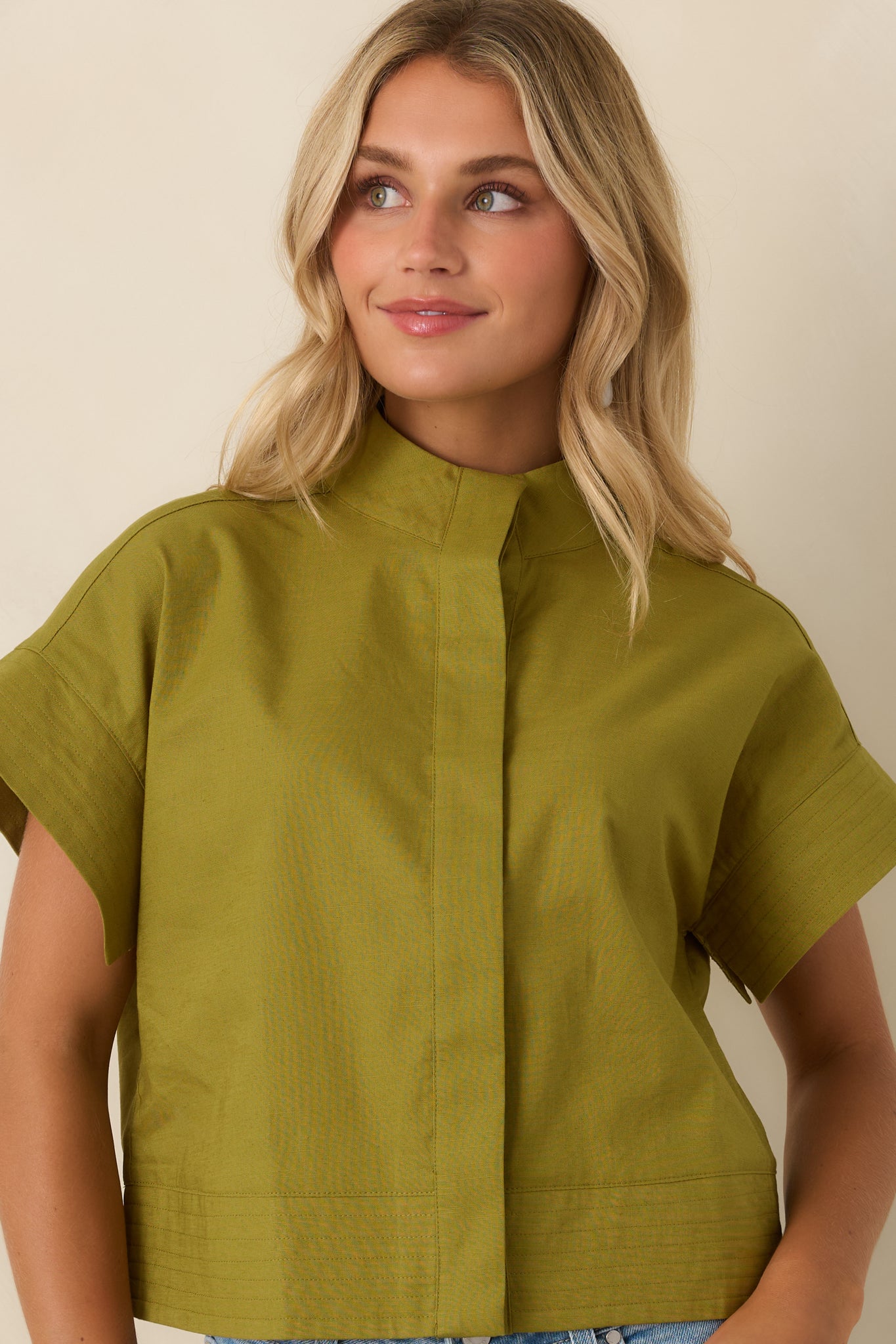 Breathable cotton linen fabric complements the relaxed drop shoulders and cuffed short sleeves of this cropped olive green top.