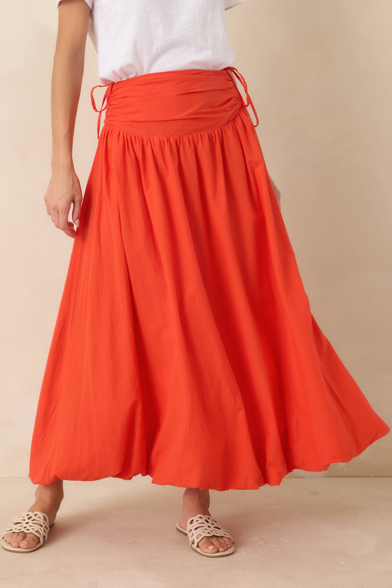 Lightweight cotton maxi skirt featuring a flattering fit through the hips, adjustable side ties, and a graceful full-length silhouette.