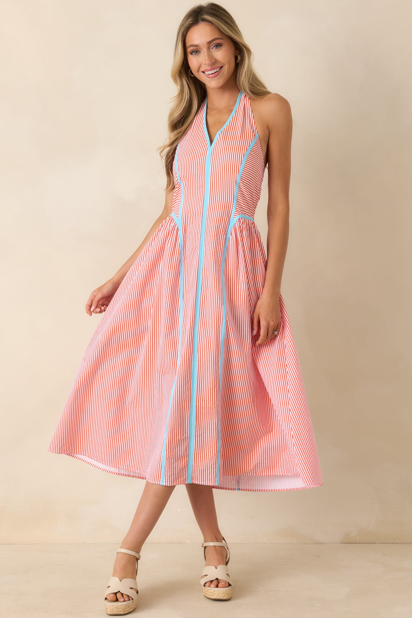 Cotton midi dress featuring a halter neckline, fitted bodice, flowy skirt, and contrasting trim details.