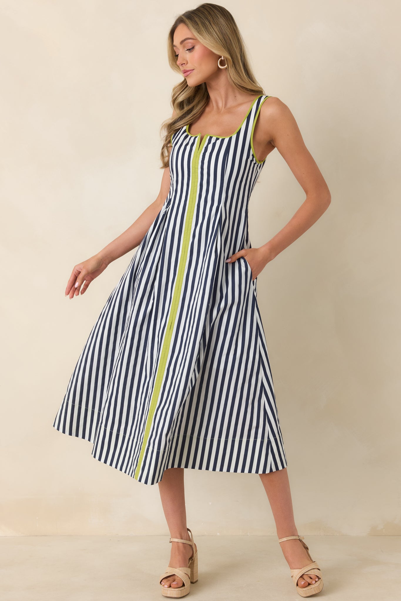 Front view of the cotton midi dress featuring a relaxed skirt, functional side pockets, and hidden side zipper.