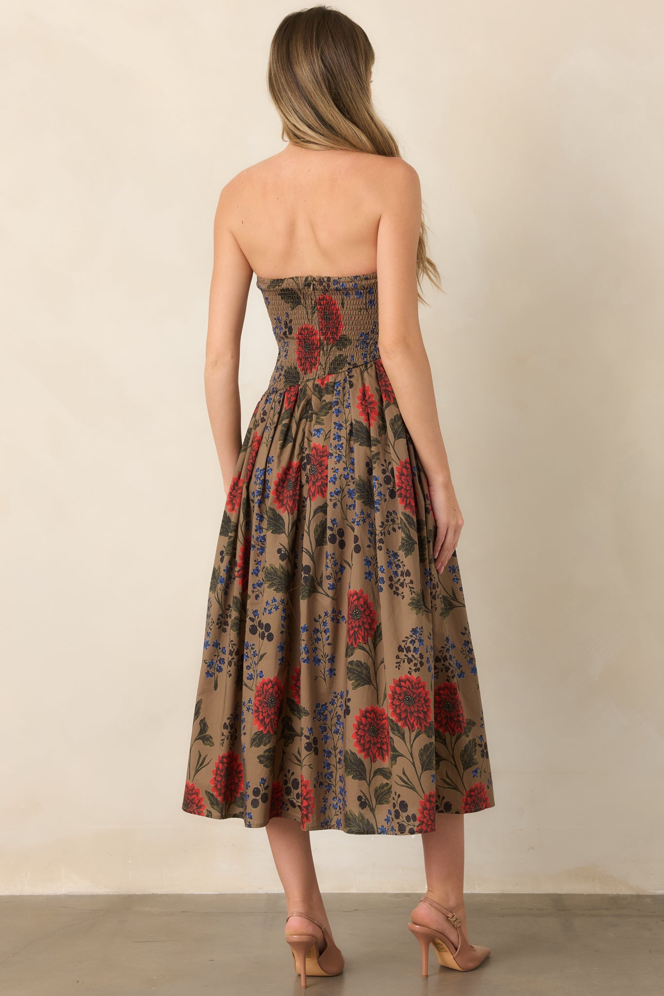 Rear view of the cotton midi dress showcasing the smocked back, concealed zipper, floral pattern, and full skirt.