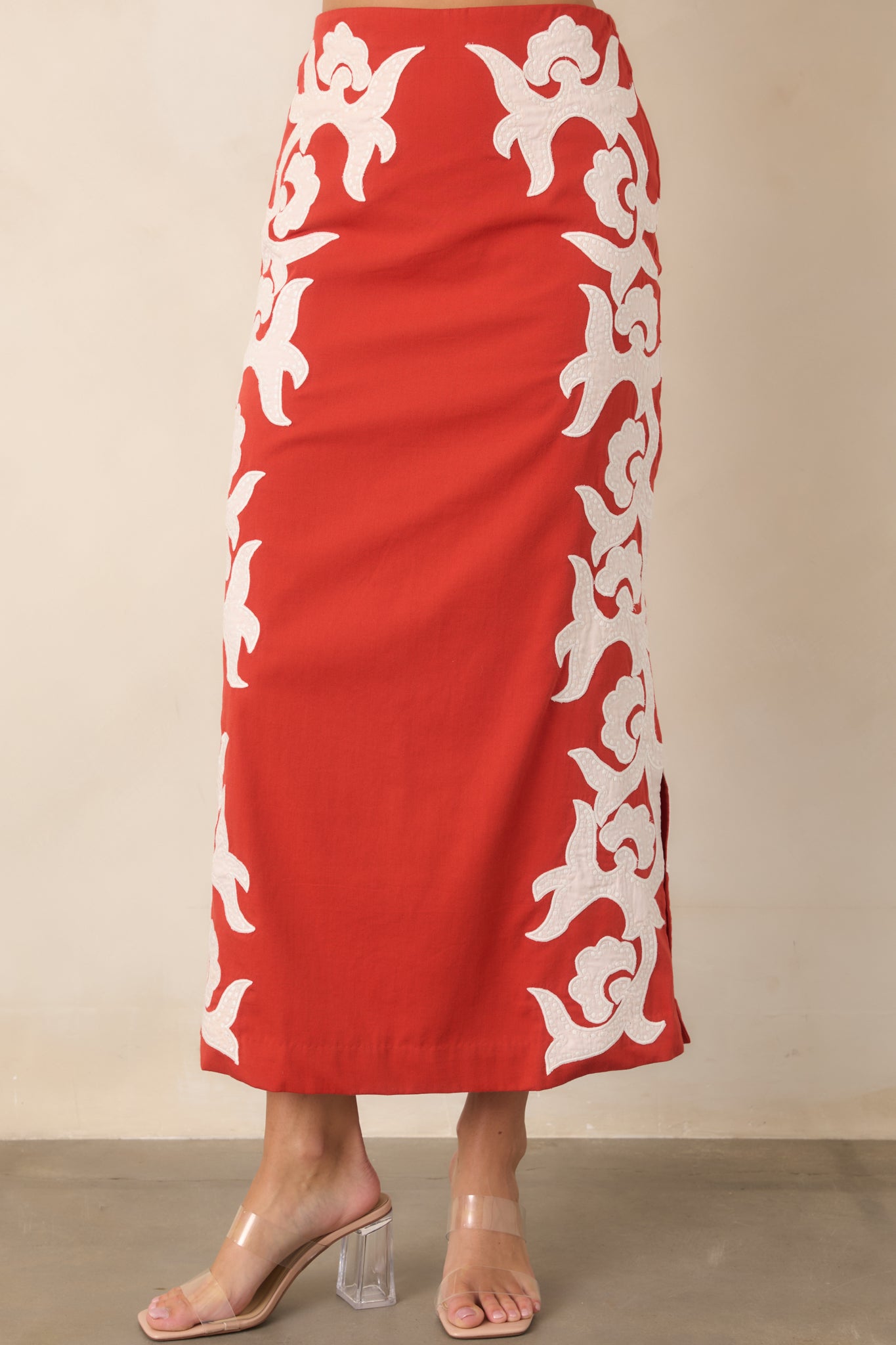 Side slit detail adds movement to the sleek cotton midi skirt while complementing its bold appliqué design.
