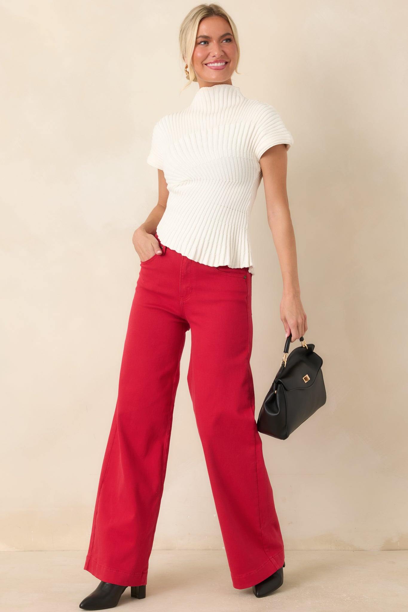 Cotton ribbed knit top featuring a sculptural silhouette, mock neckline, cap sleeves, and an asymmetrical hemline.