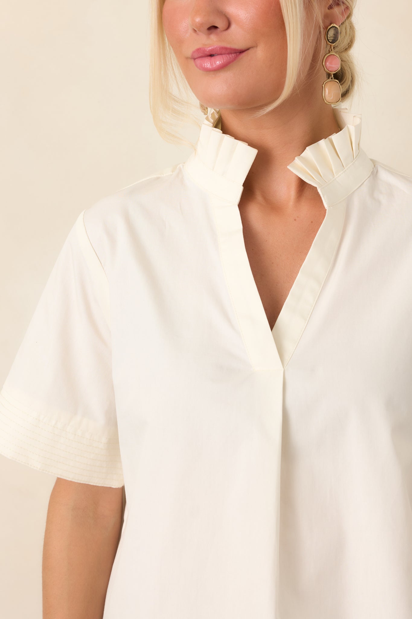 Close view of the breathable cotton fabric and refined neckline, emphasizing the dimensional ruffle collar and graceful drape.