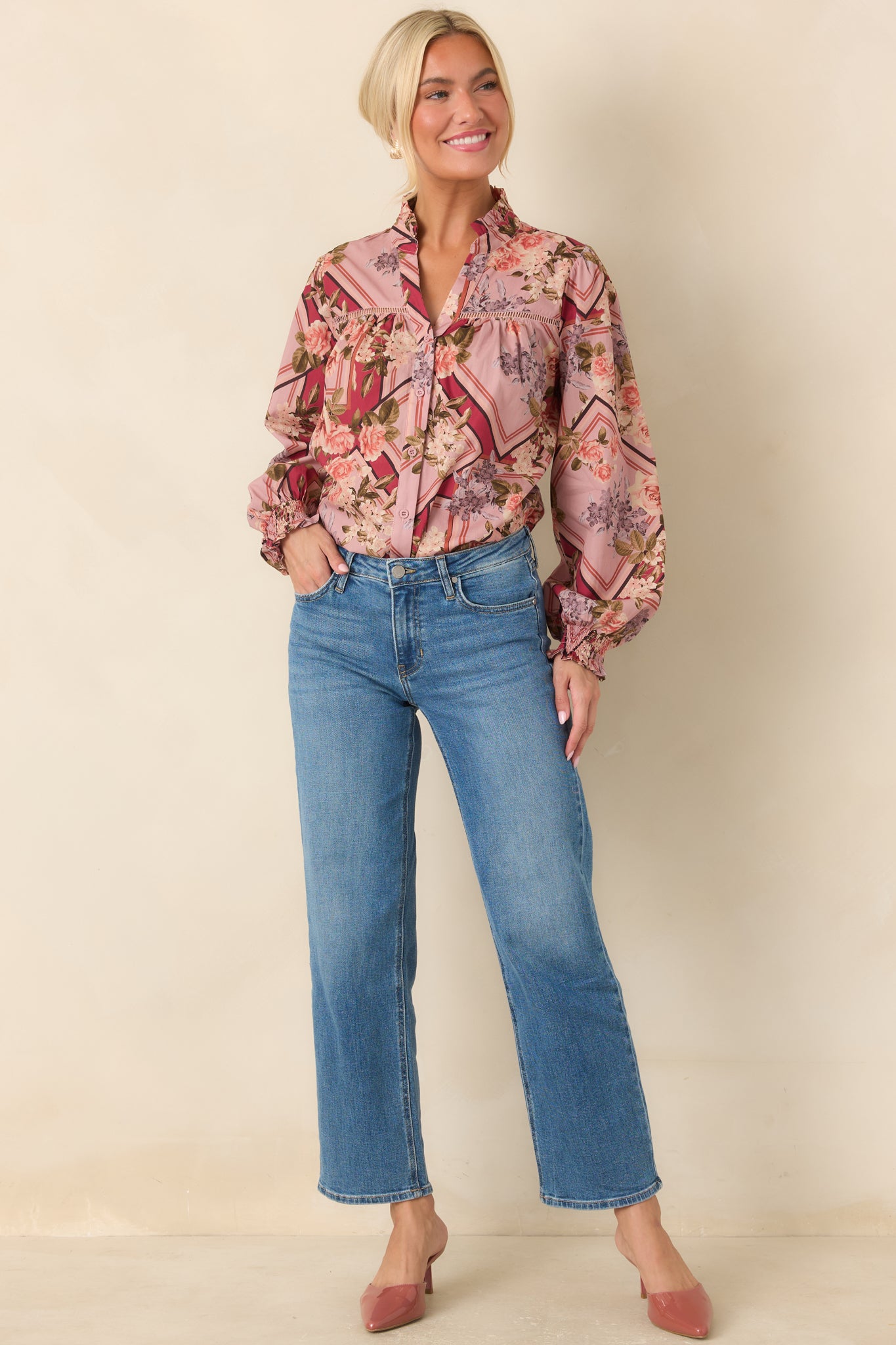 100% cotton top featuring a ruffled stand collar, button-front closure, gathered yoke, voluminous long sleeves, and smocked cuffs.