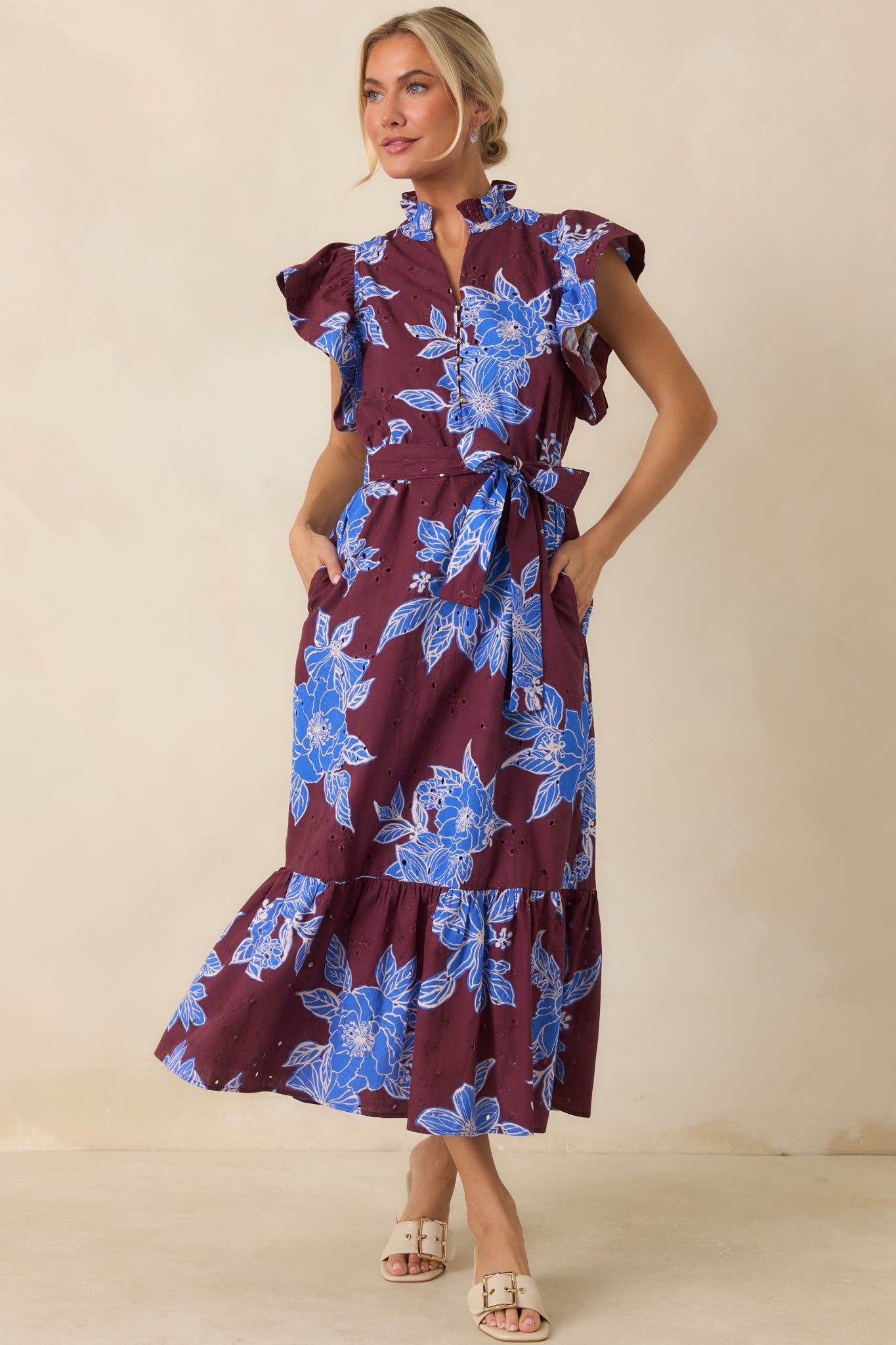Cotton dress featuring a ruffled mock neckline, split V-neckline with gold button accents, flutter sleeves, and a softly ruffled hem.