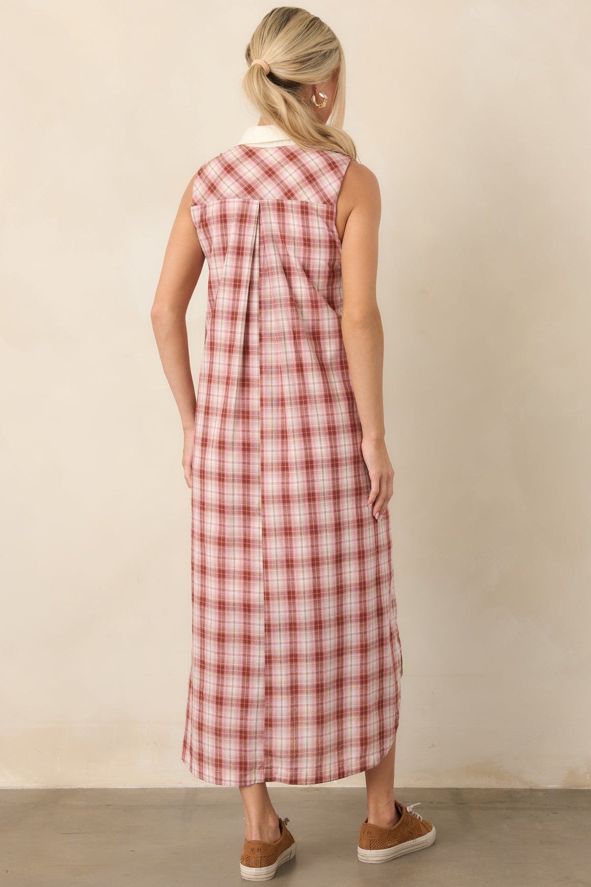 Rear view of the relaxed 100% cotton dress, highlighting its sleeveless cut, softly draped shape, and clean ivory-trimmed finish.