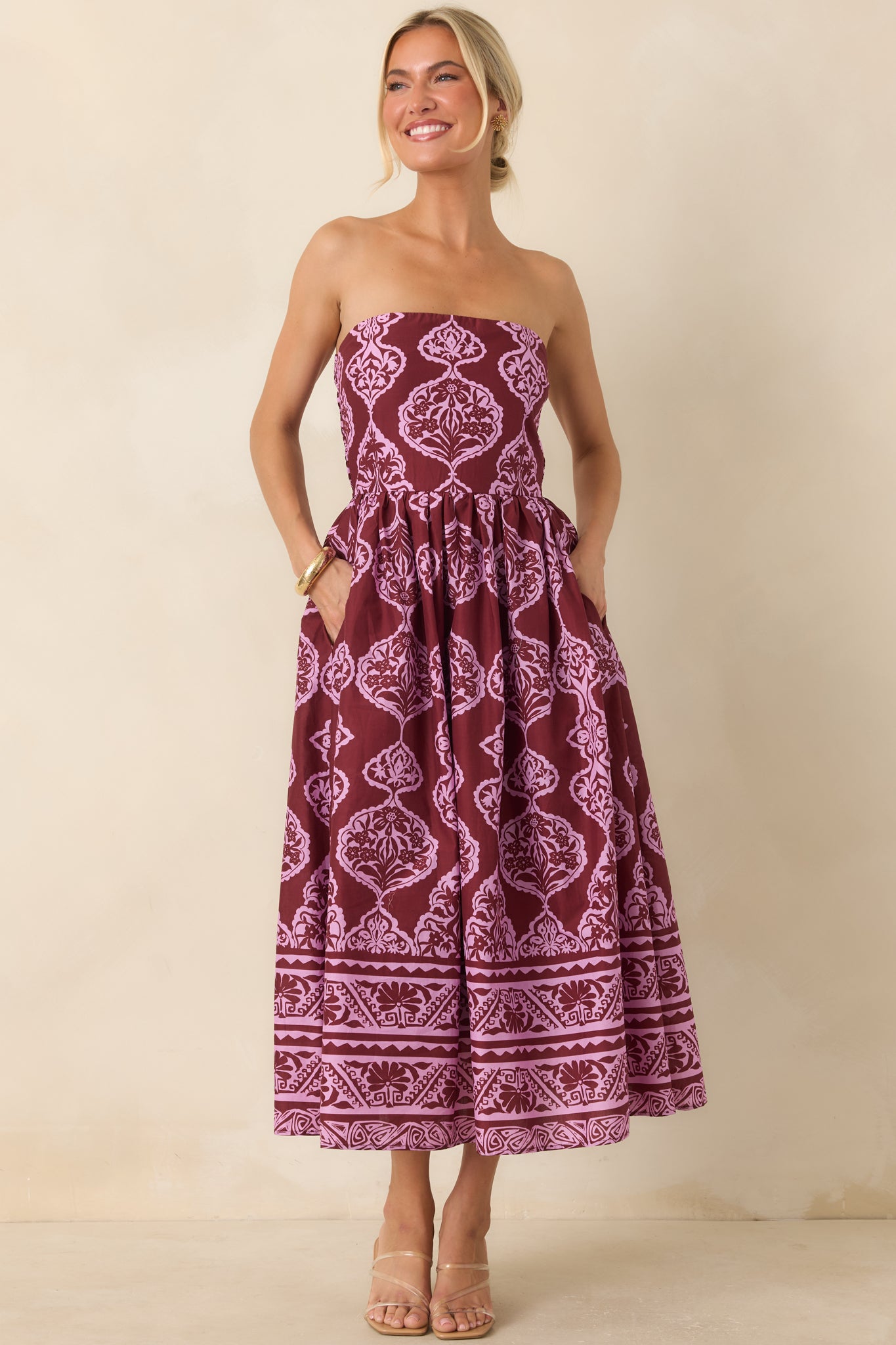 Cotton strapless dress with a detailed pink and wine pattern, full gathered skirt, concealed zipper, and polished silhouette.