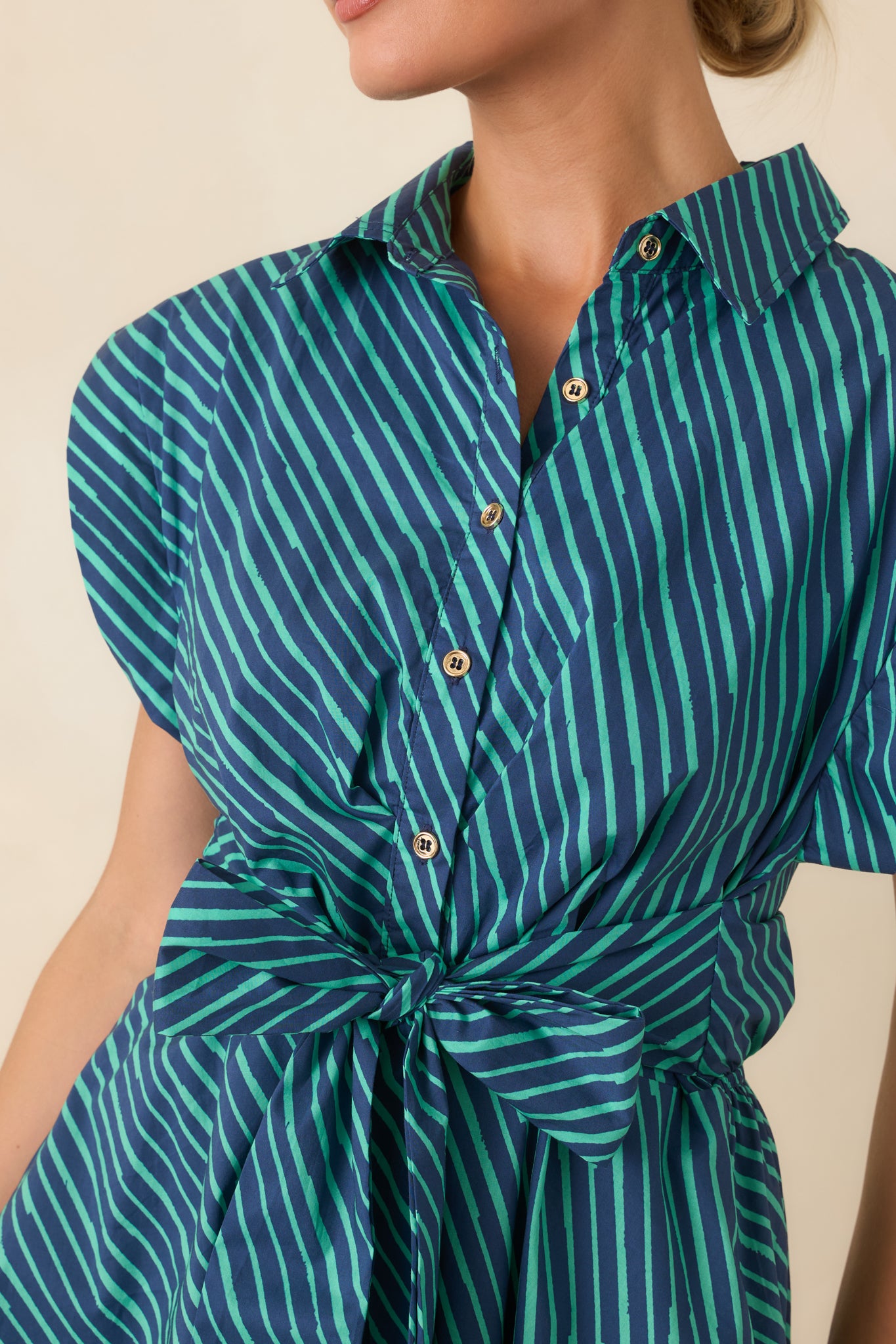 Close-up of the cotton fabric displaying the teal and navy stripe print, button details, and smooth lined finish.