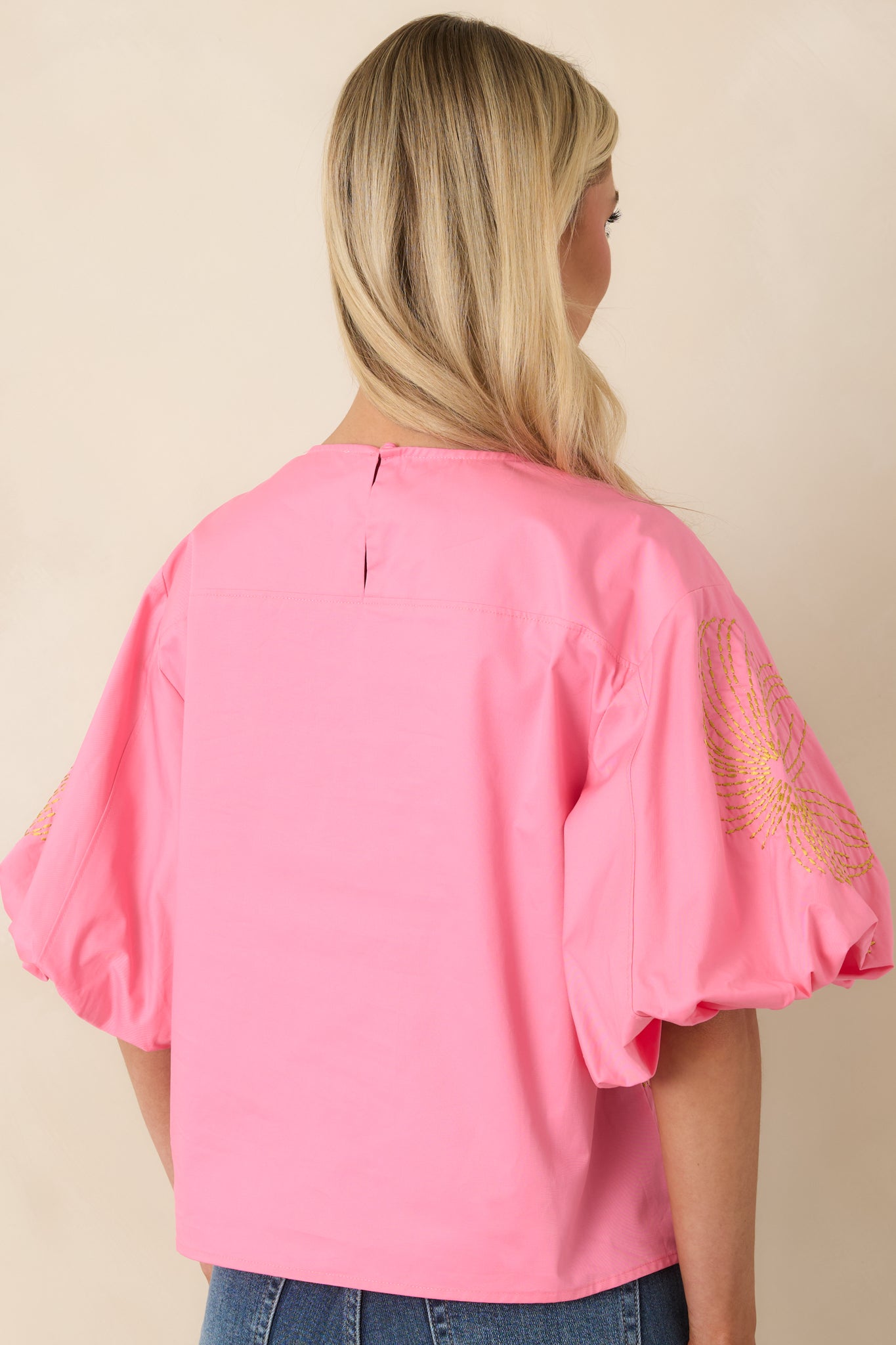 Cotton top featuring a rear keyhole opening with a single button closure for a refined finish.